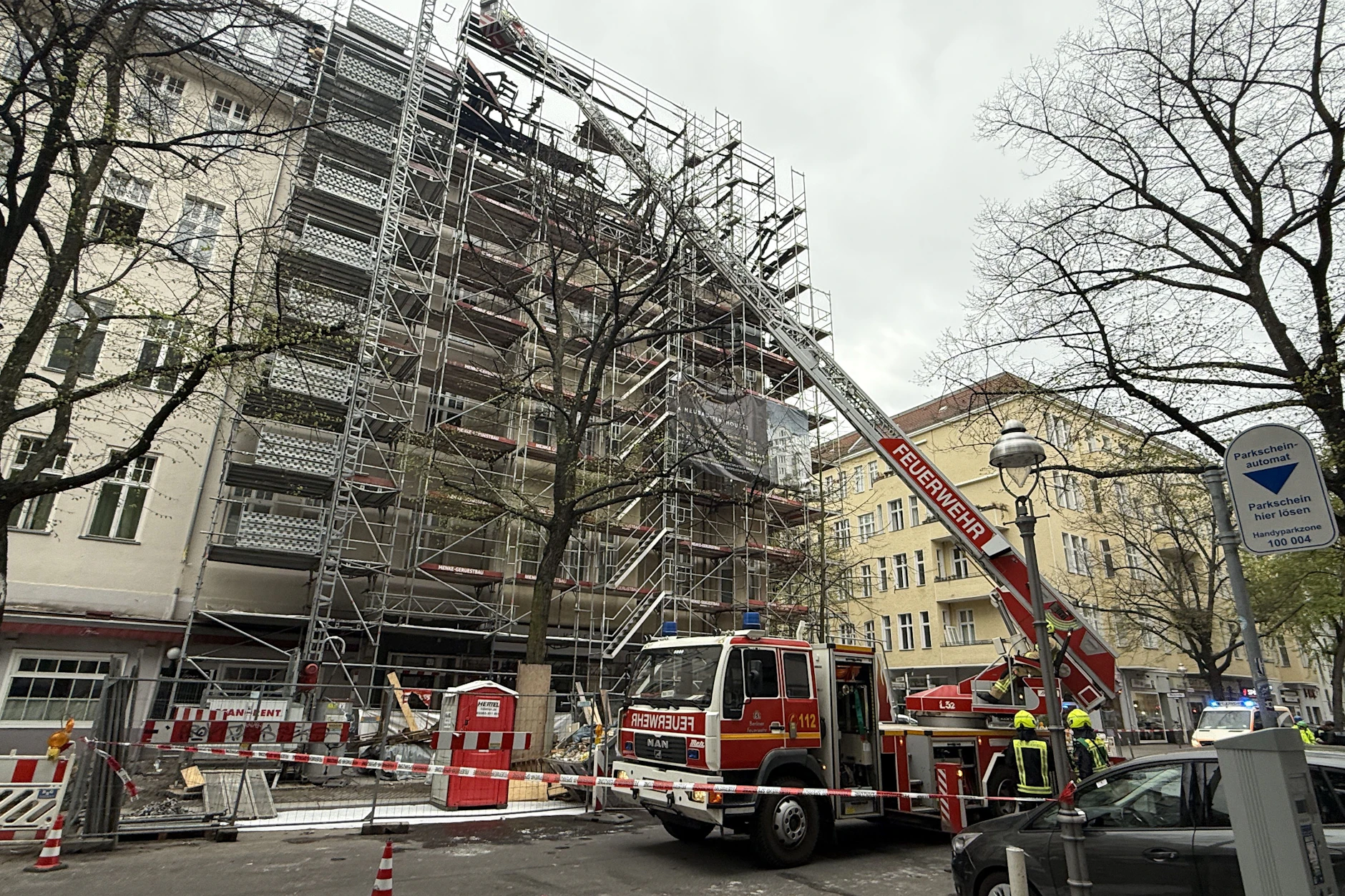 Am Tag nach dem Dachstuhlbrand in der City West steht ein Leiterwagen der Feuerwehr vor dem Haus.