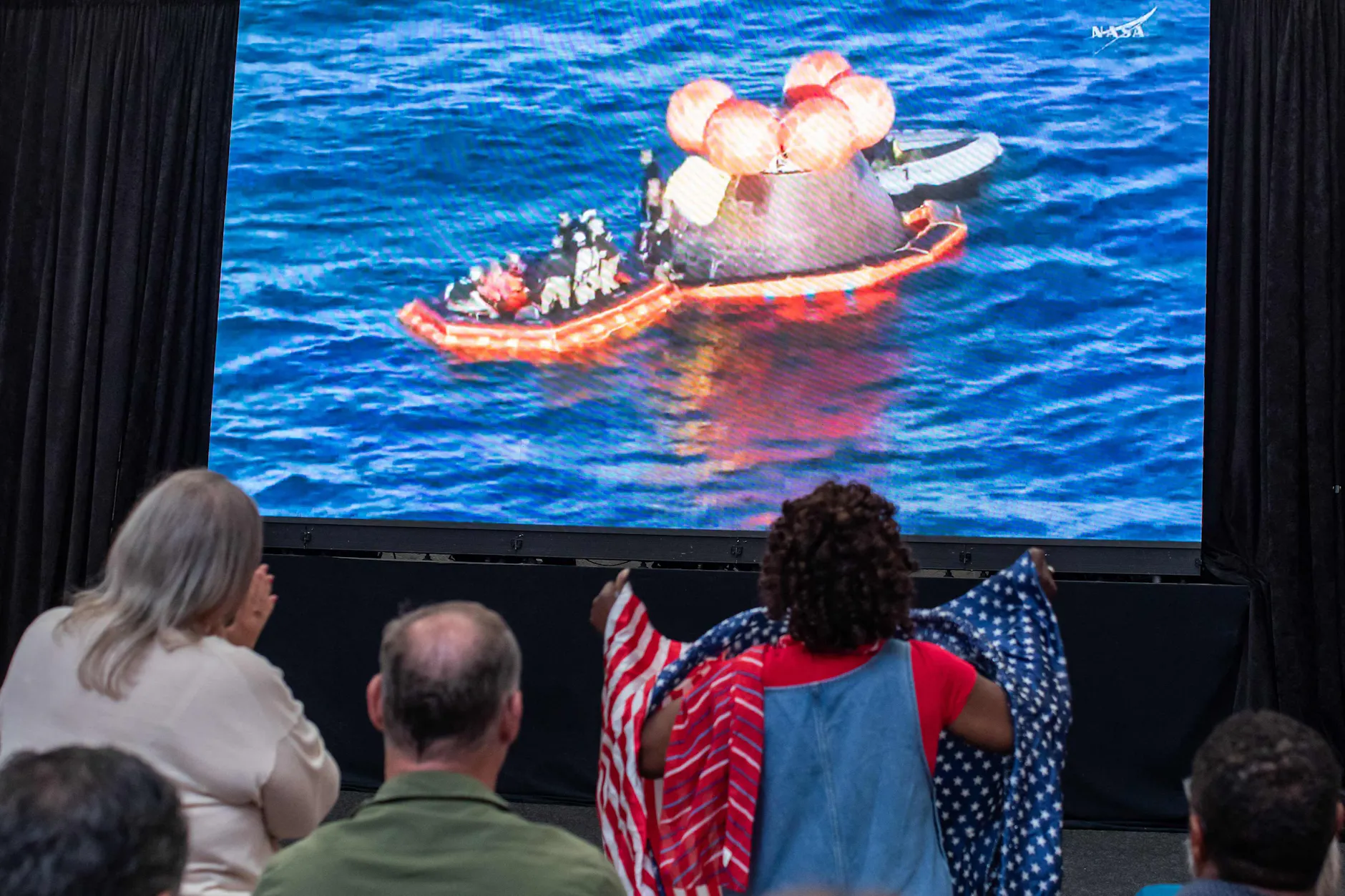 Besucher verfolgen im San Diego Air and Space Museum die Live-Übertragung der Wasserung der Artemis-II-Crew im Pazifik.