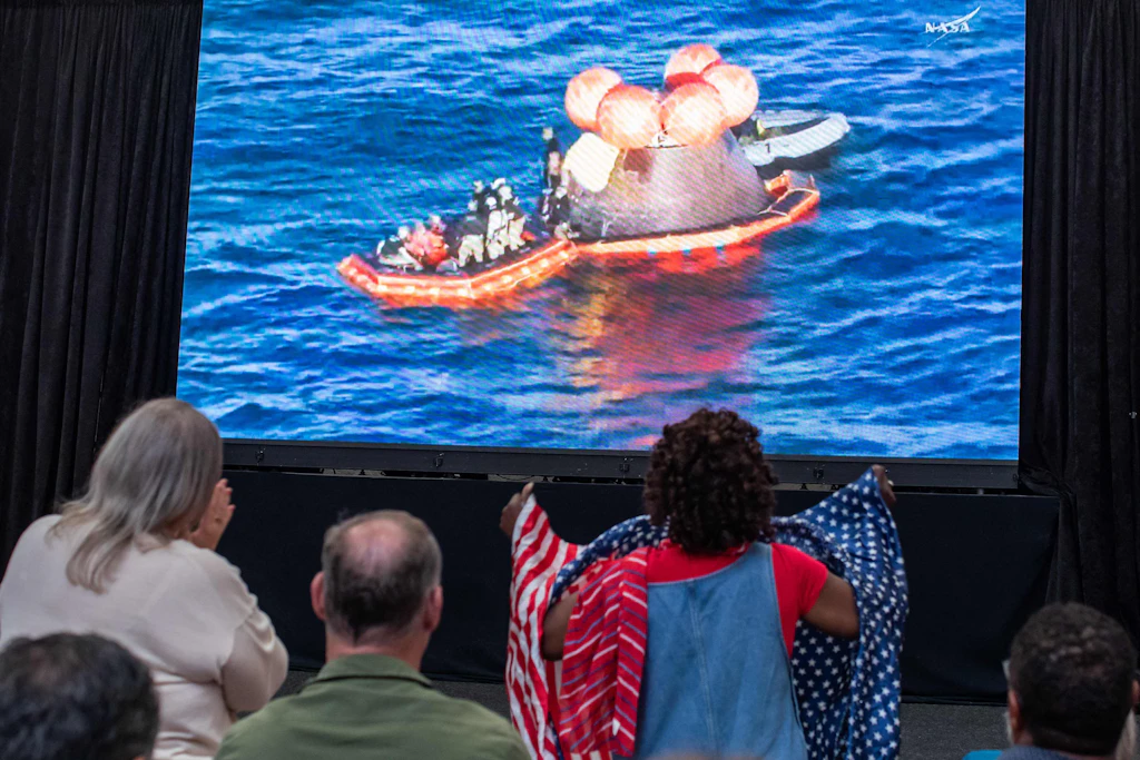 Besucher verfolgen im San Diego Air and Space Museum die Live-Übertragung der Wasserung der Artemis-II-Crew im Pazifik.