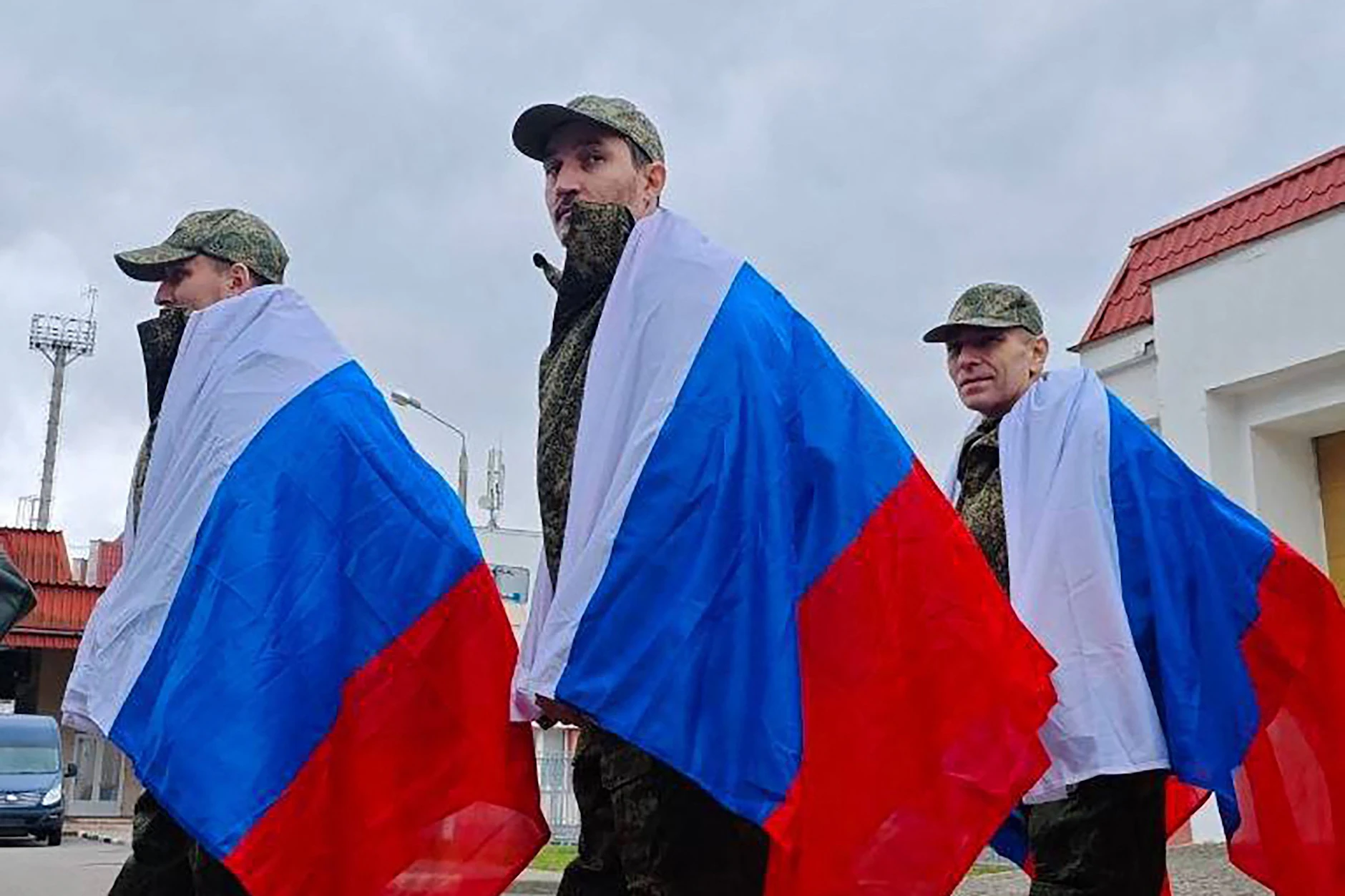 Freigelassene russische Kriegsgefangene nach dem Austausch – in Nationalflaggen gehüllt.