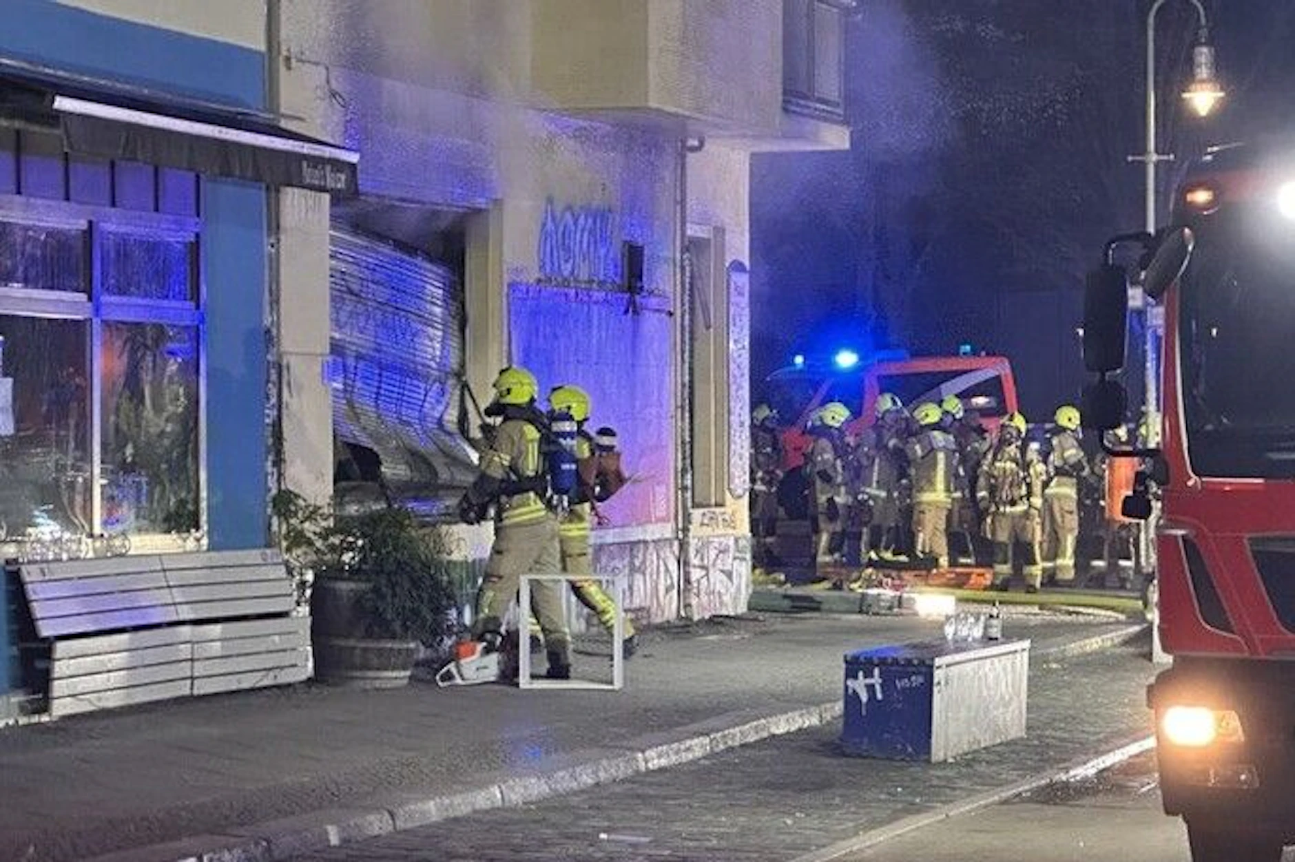 Einsatzkräfte der Feuerwehr am Lokal, in dem das Feuer ausbrach.