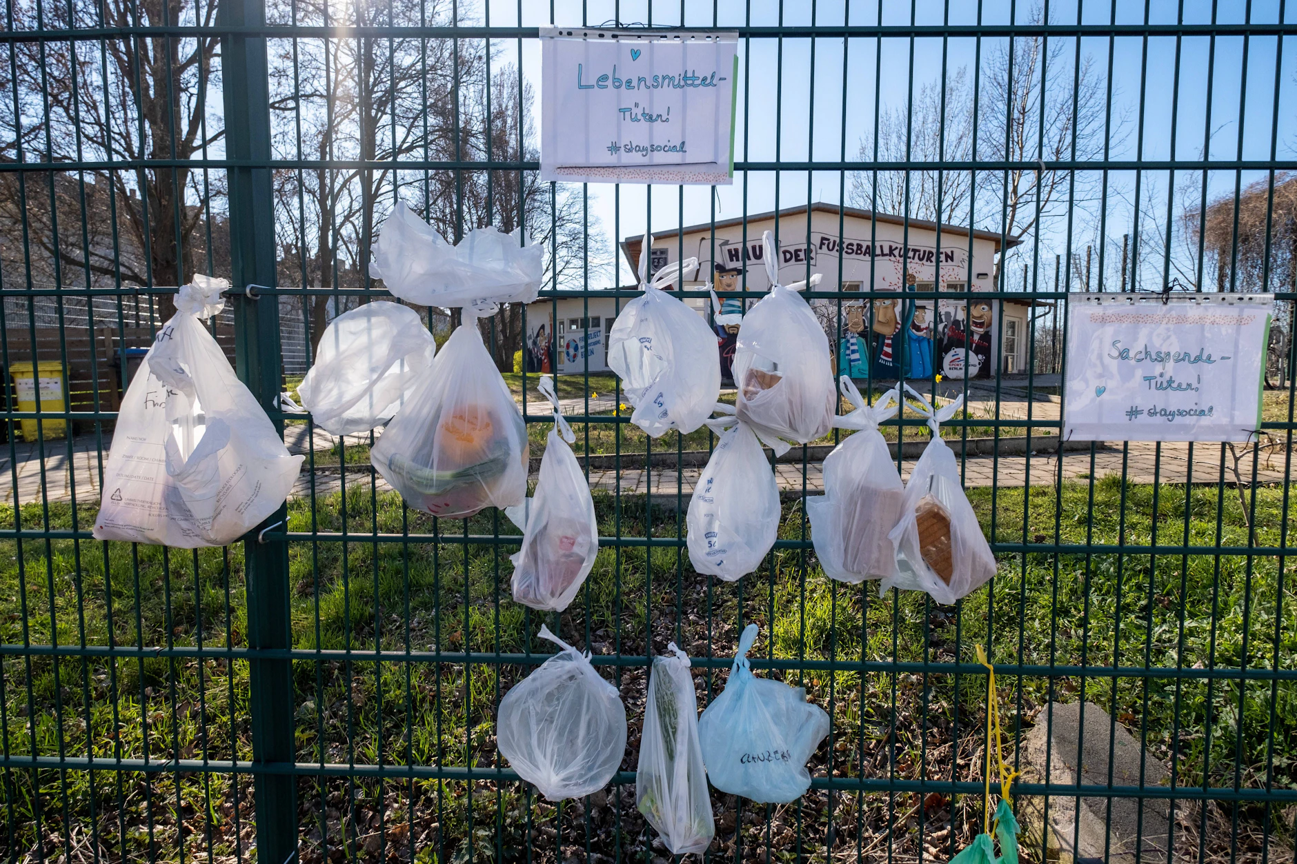 Am Zaun des geschlossenen Friedrich-Ludwig-Jahn-Sportparks hängen Lebensmittel- und Sachspenden für Obdachlose.