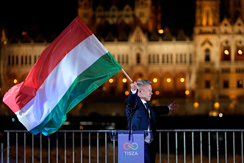 Peter Magyar, der Vorsitzende der Oppositionspartei Tisza, schwenkt nach der Parlamentswahl eine Nationalflagge.