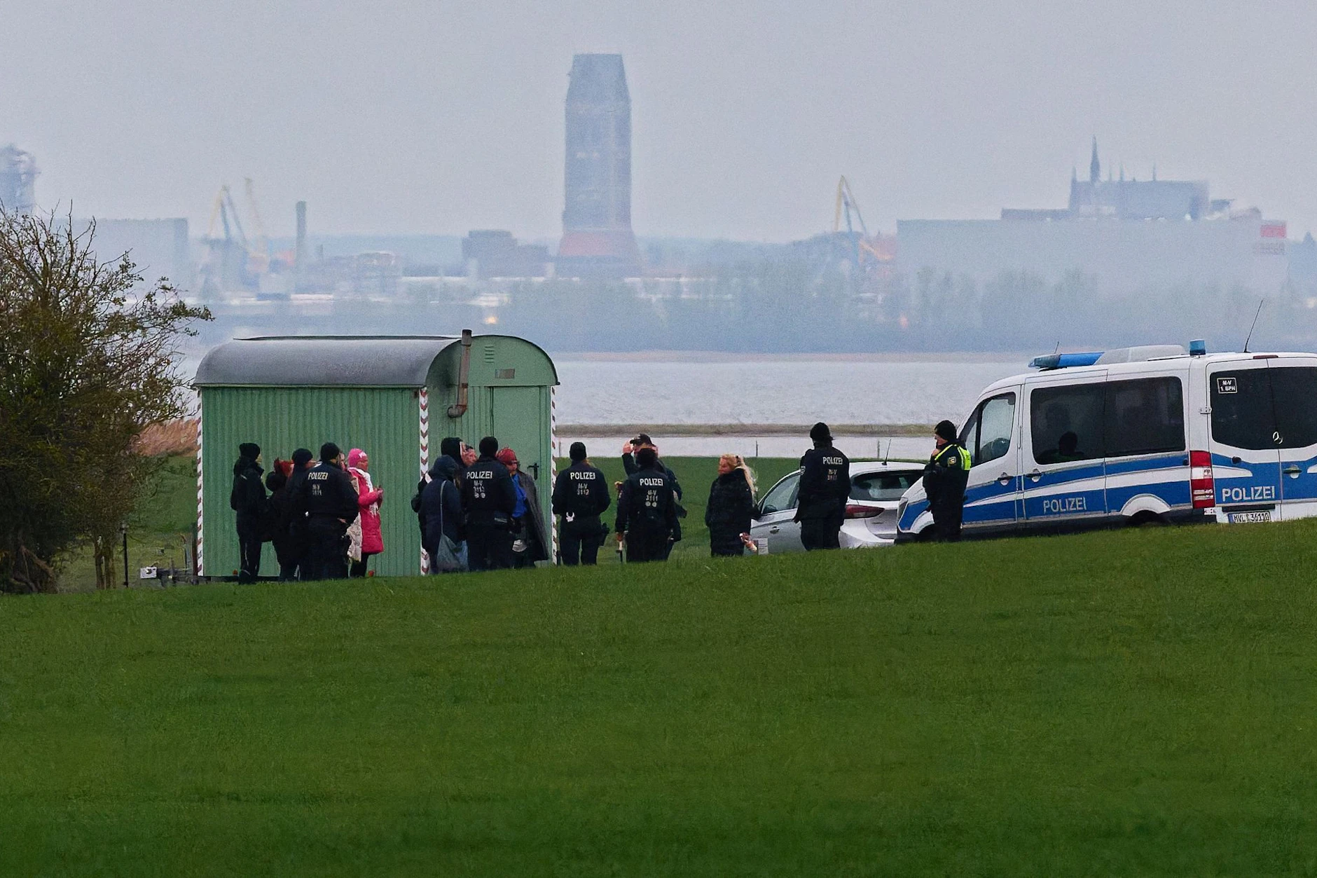 Teilnehmer einer Demonstration für den gestrandeten Wal an einer Bucht der Ostsee-Insel Poel werden von Polizisten zurückgedrängt.