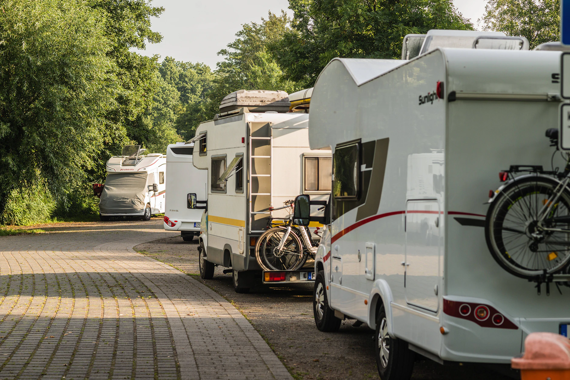 Wohnmobile stehen im Sommer auf einem Camperstellplatz im Spreewald, Brandenburg. Haben Sie Lust bekommen? Besuchen Sie die Campermesse.