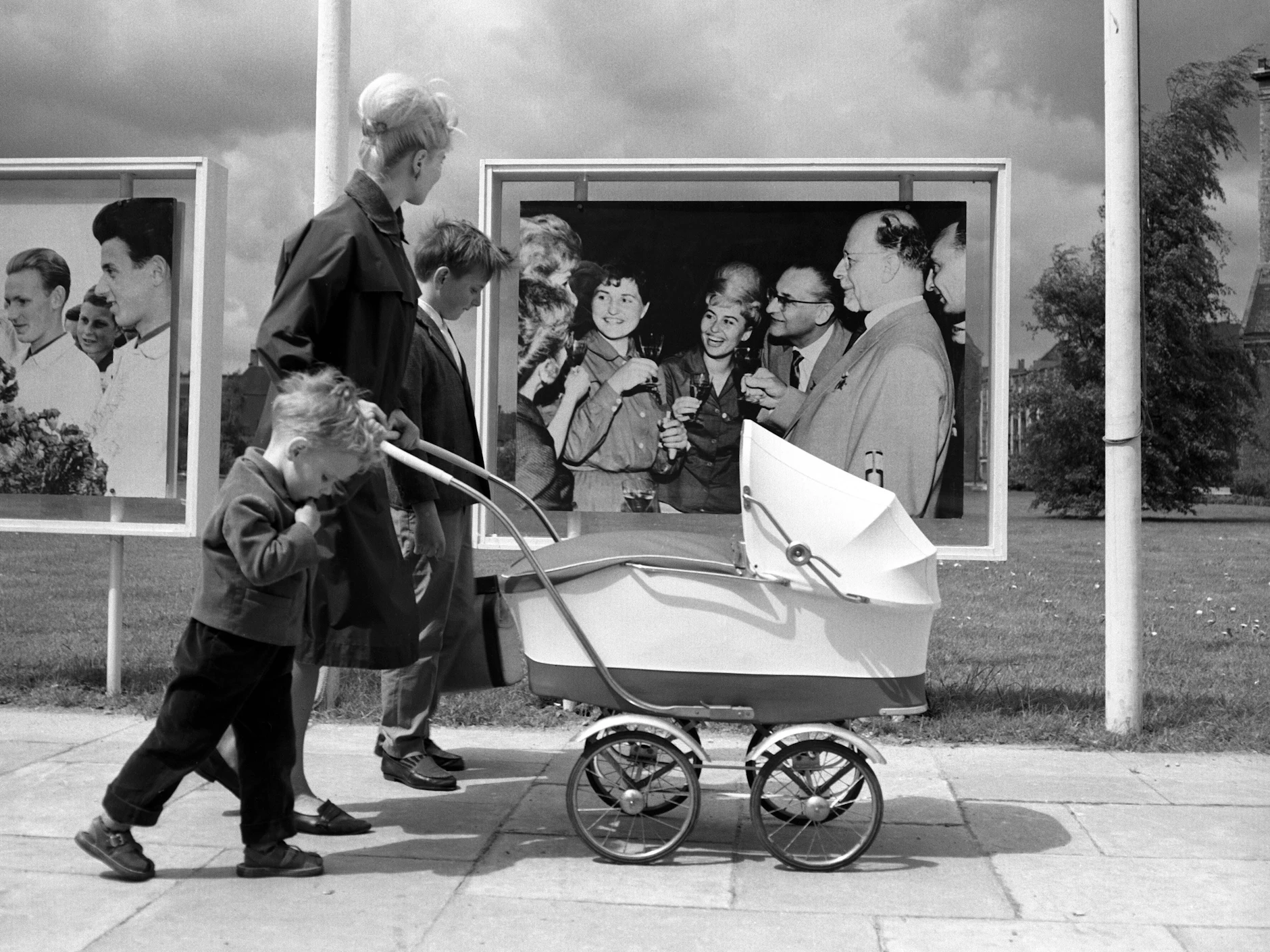 Personenkult gehörte damals dazu: Eine junge Mutter mit Kinderwagen und ihren Kindern fährt vor einem Foto von Walter Ulbricht in Ost-Berlin vorbei. 