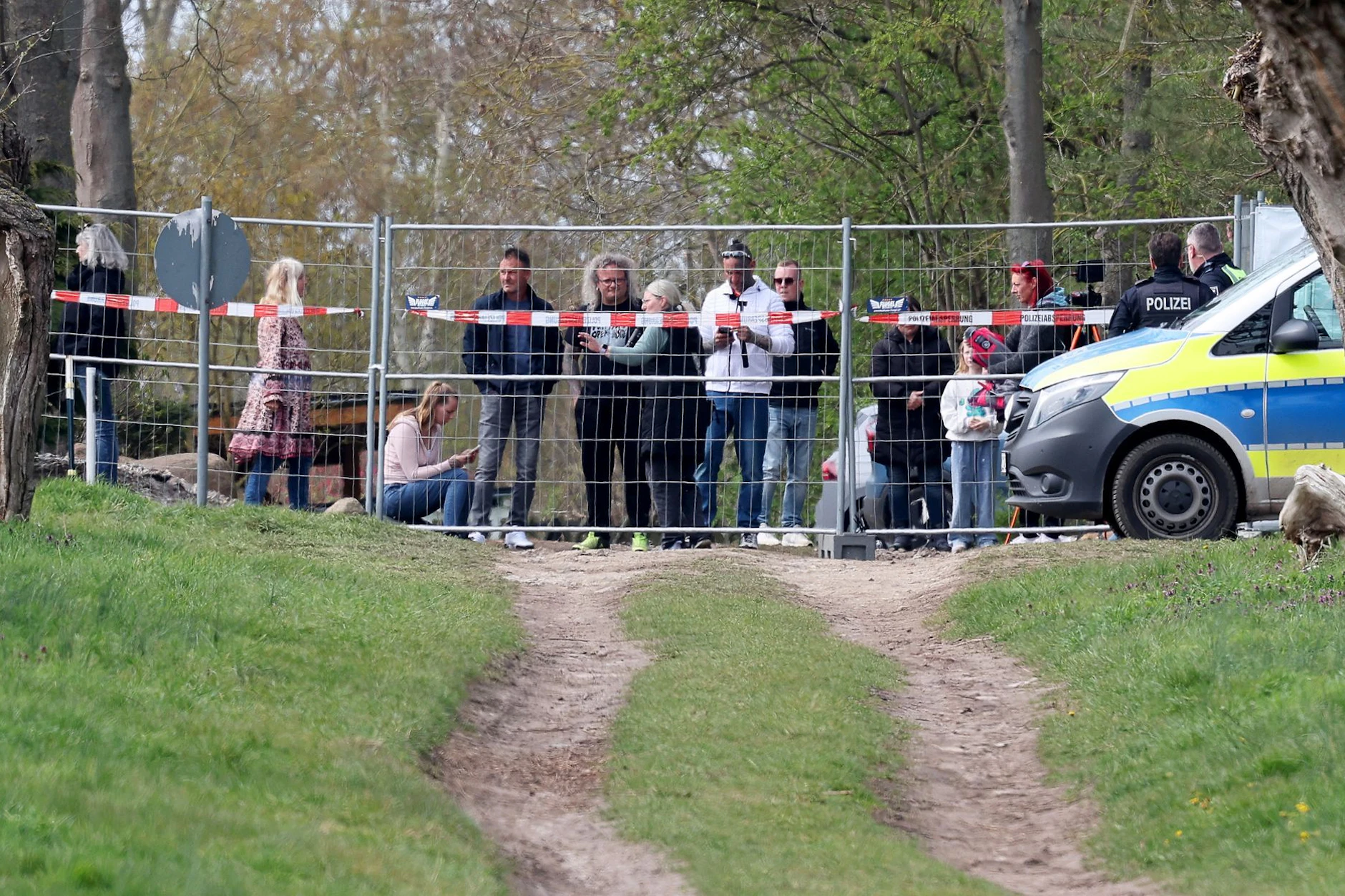 Schaulustige und Demonstranten stehen hinter einer Polizeiabsperrung, in der Nähe des gestrandeten Buckelwals.