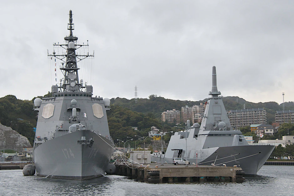 Der Lenkwaffenzerstörer Kirishima DDG-174 und die Fregatte Kumano FFM-2 liegen vor einem japanischen Marinestützpunkt vor Anker.