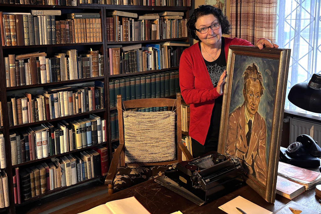 Die Vorsitzende des Literaturvereins „Ehm Welk-Haus e.V“ Bärbel Giersberg mit Ehm Welk-Porträt in seinem original erhaltenem Bad Doberaner Arbeitszimmer.