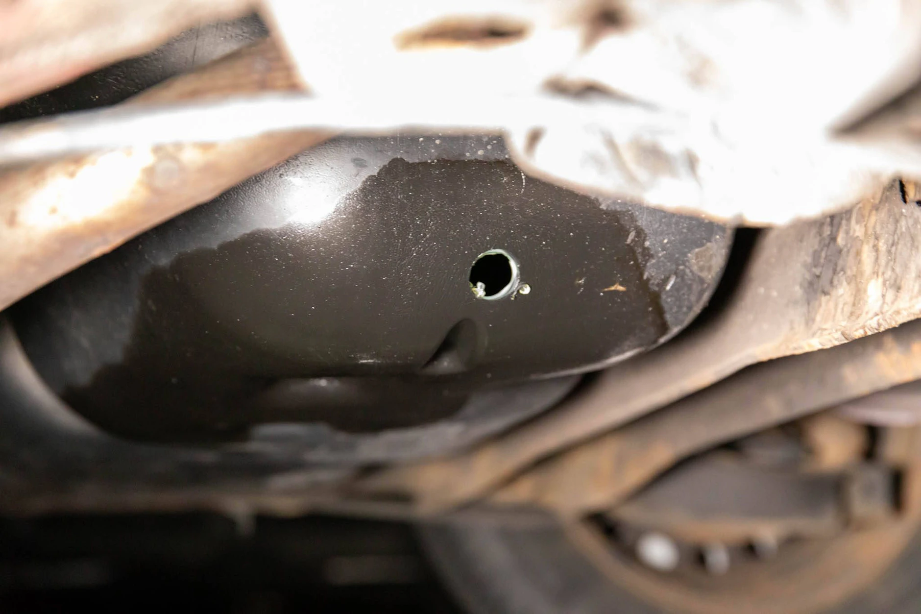 Auf einem Pendlerparkplatz haben Diebe den Tank eines Pkw aufgebohrt, um Benzin zu klauen.