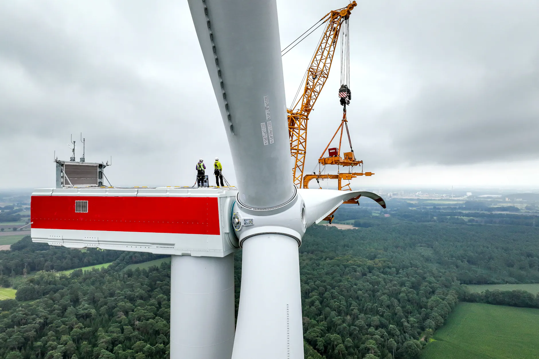 Ein Rotorblatt wird an eine Windenergieanlage montiert.