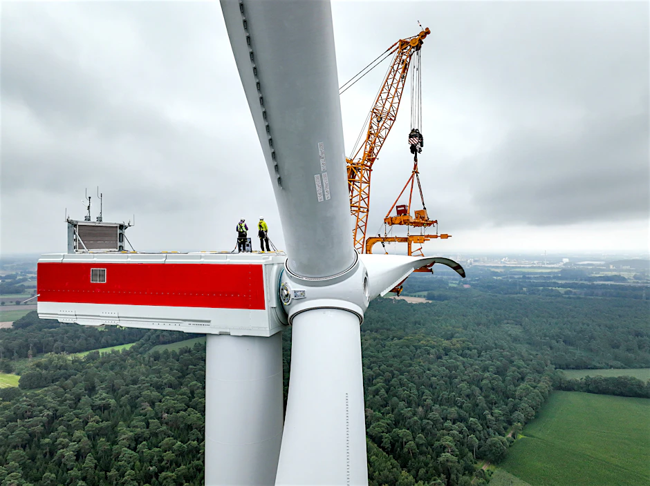 Ein Rotorblatt wird an eine Windenergieanlage montiert.