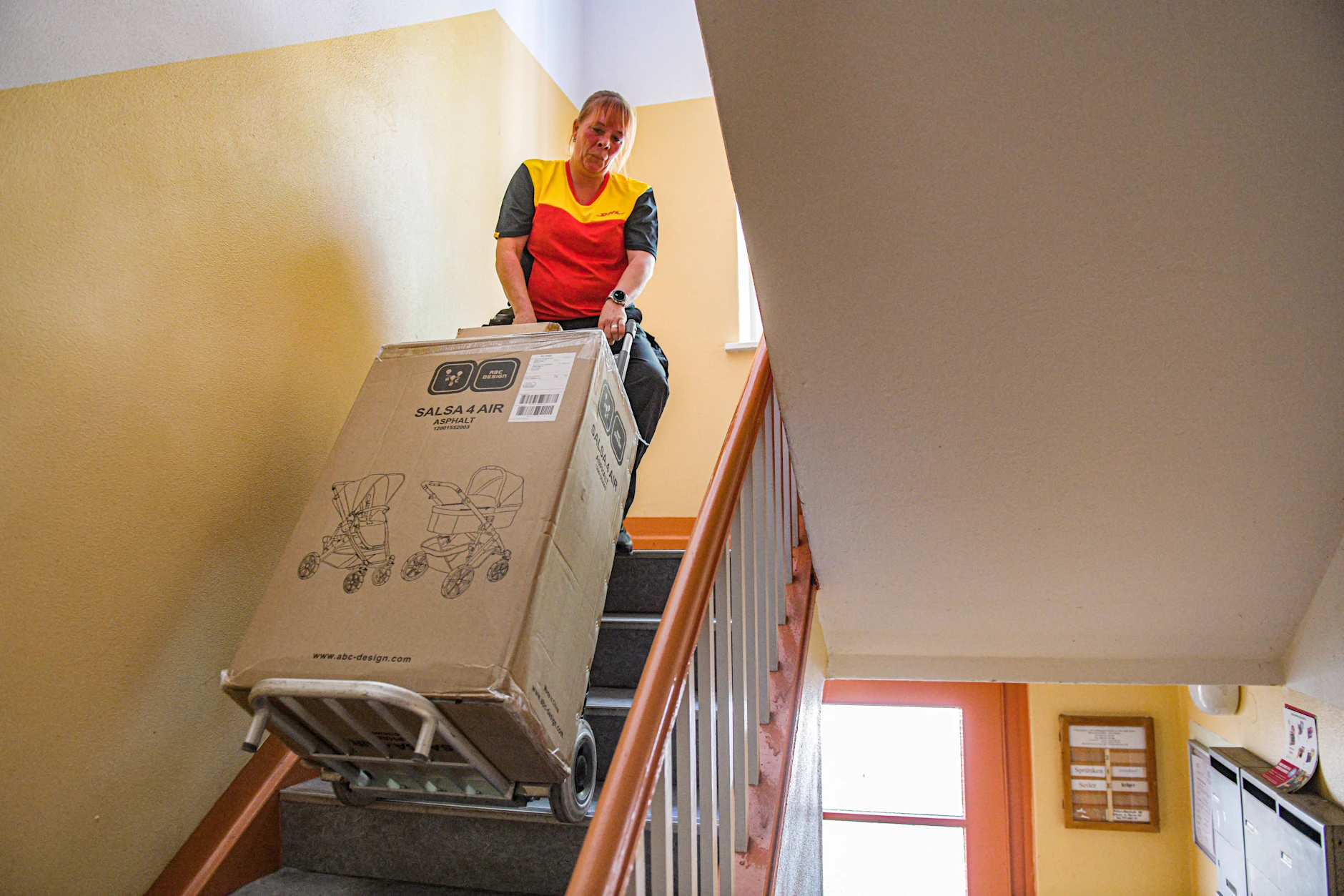 Große Pakete hochschleppen gehört zum Alltag eines DHL-Boten.