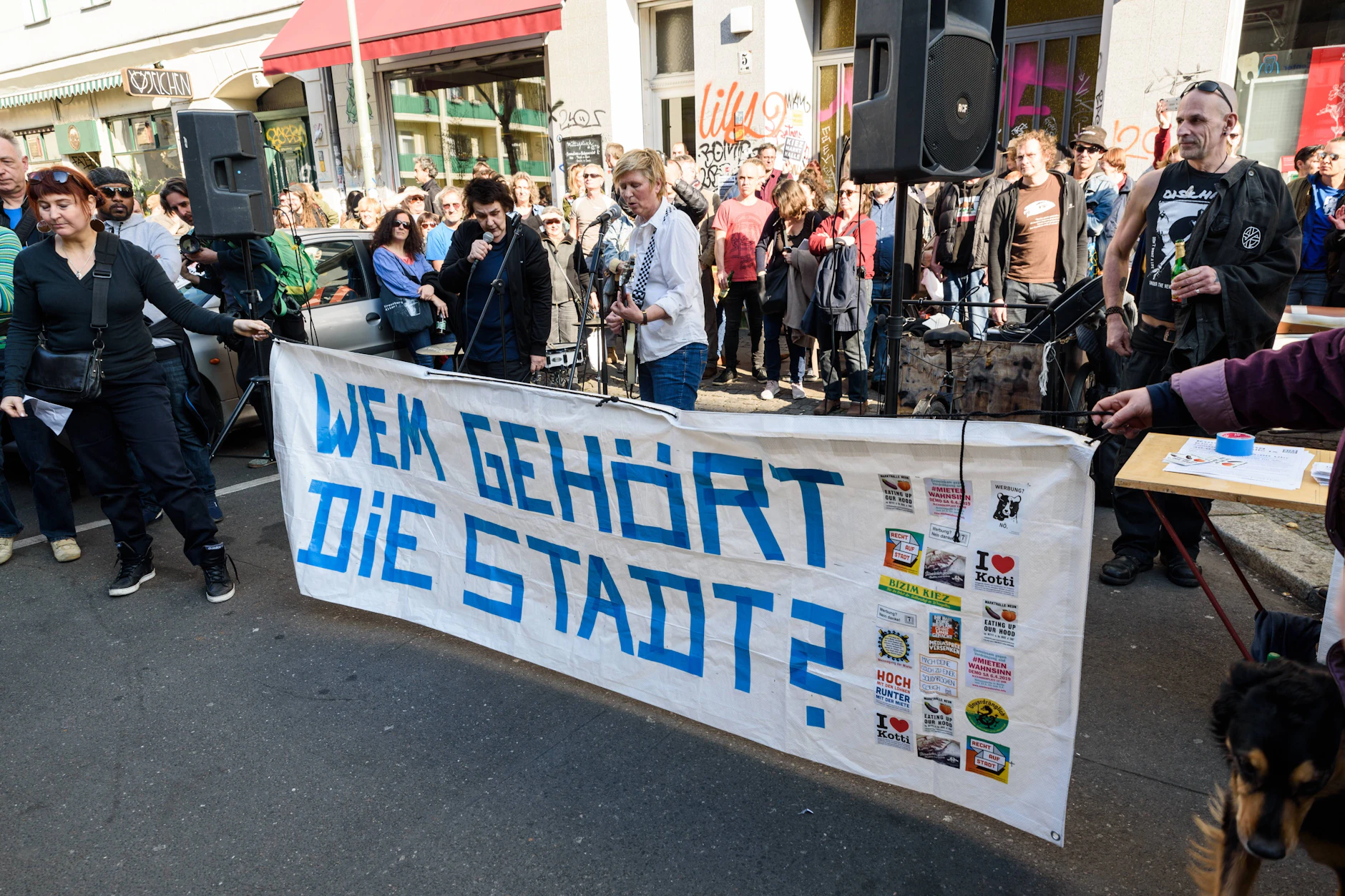Anwohner demonstrieren vor der Markthalle 9 in Berlin-Kreuzberg und stellen via Plakat eine Kernfrage.