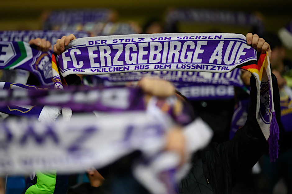 Auch in Krisenzeiten halten Aues Fans ihre Fanschals hoch. Nach 23 Jahren Profifußball stehtnun der Gang in die Regionalliga bevor.