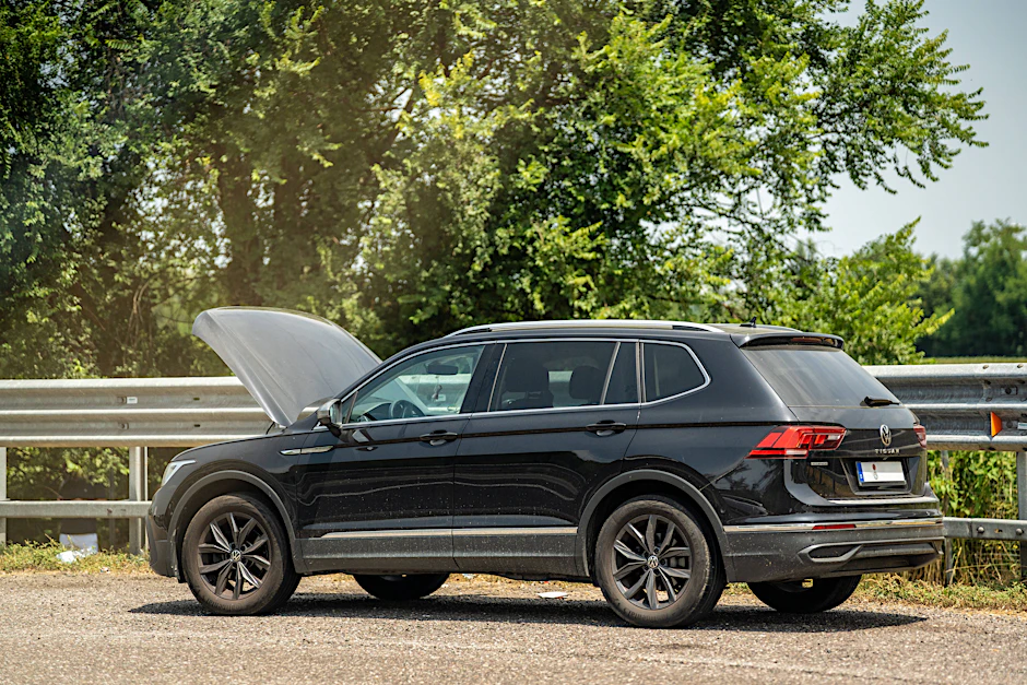 Ein SUV mit geöffneter Motorhaube steht am Straßenrand einer Autobahn.