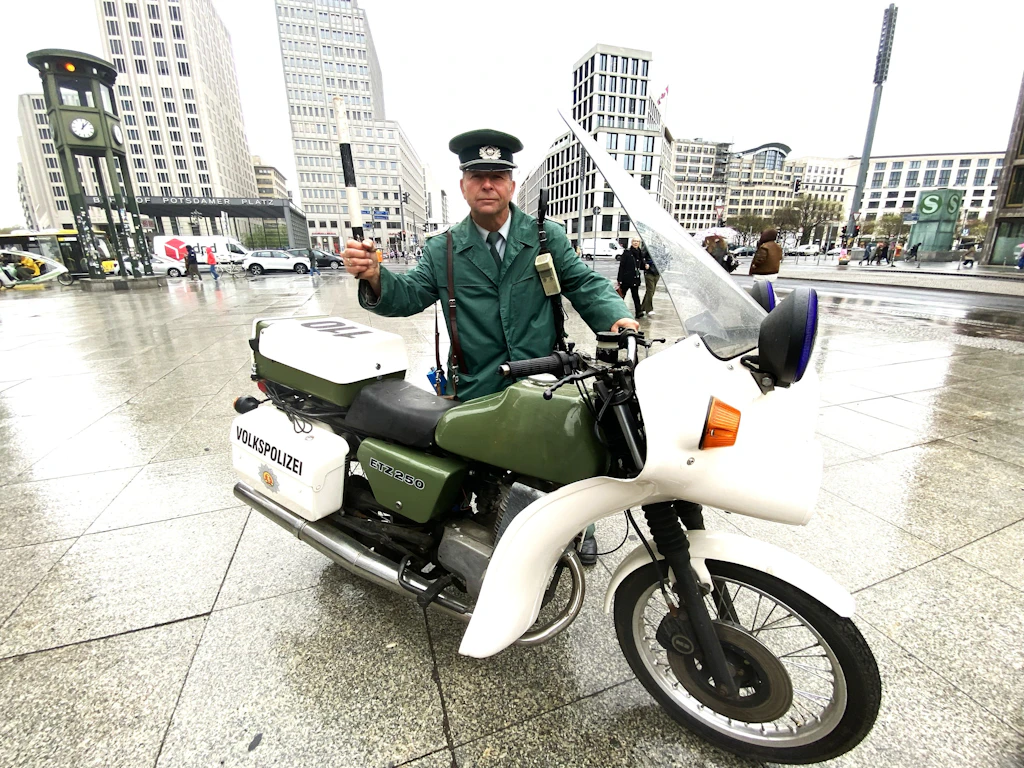Wo einst die Mauer stand, baut ein Volkspolizist die DDR wieder auf
