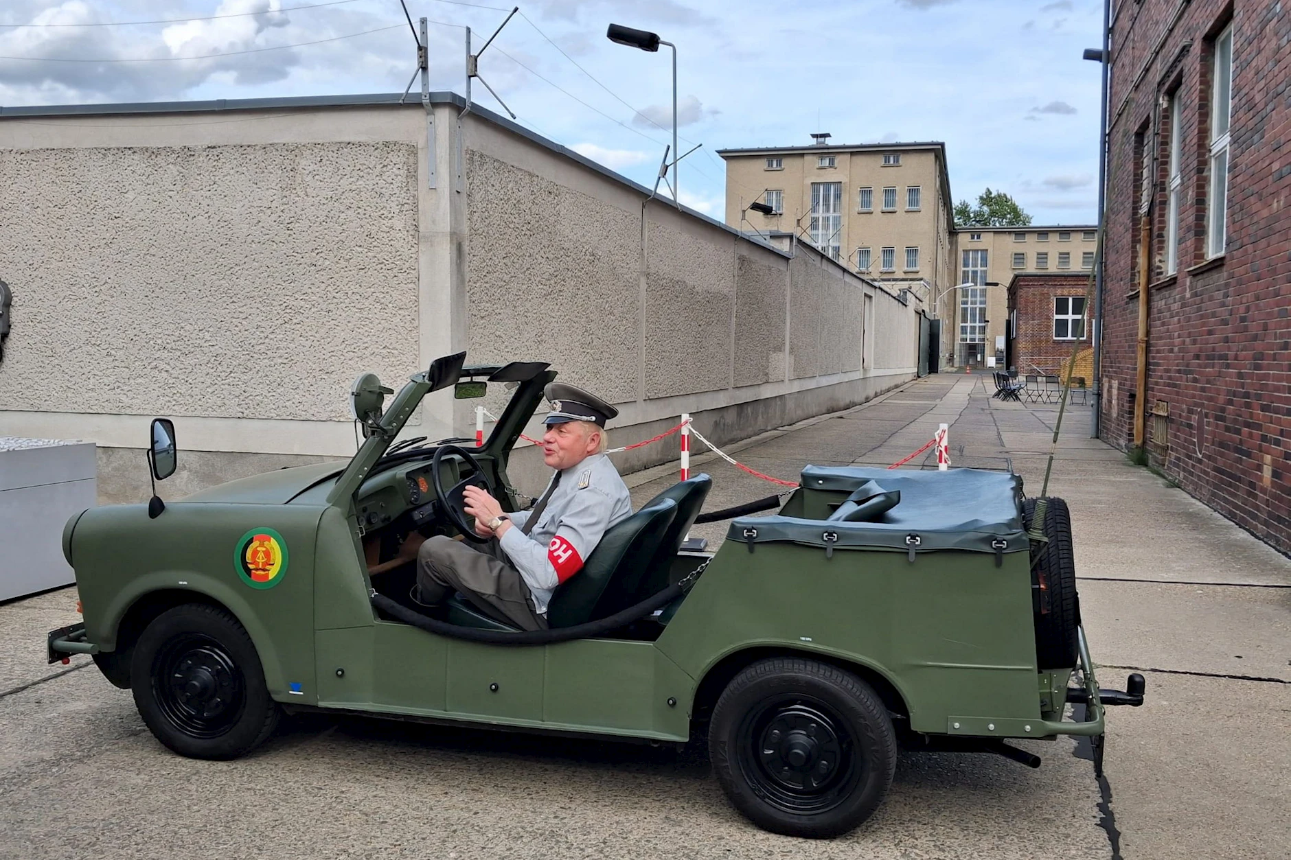 Dreister Auftritt: Am 1. Juni 2025 fährt ein Mann in NVA-Uniform in einem Armee-Trabant auf dem Gelände der Stasiopfer-Gedenkstätte Hohenschönhausen vor.
