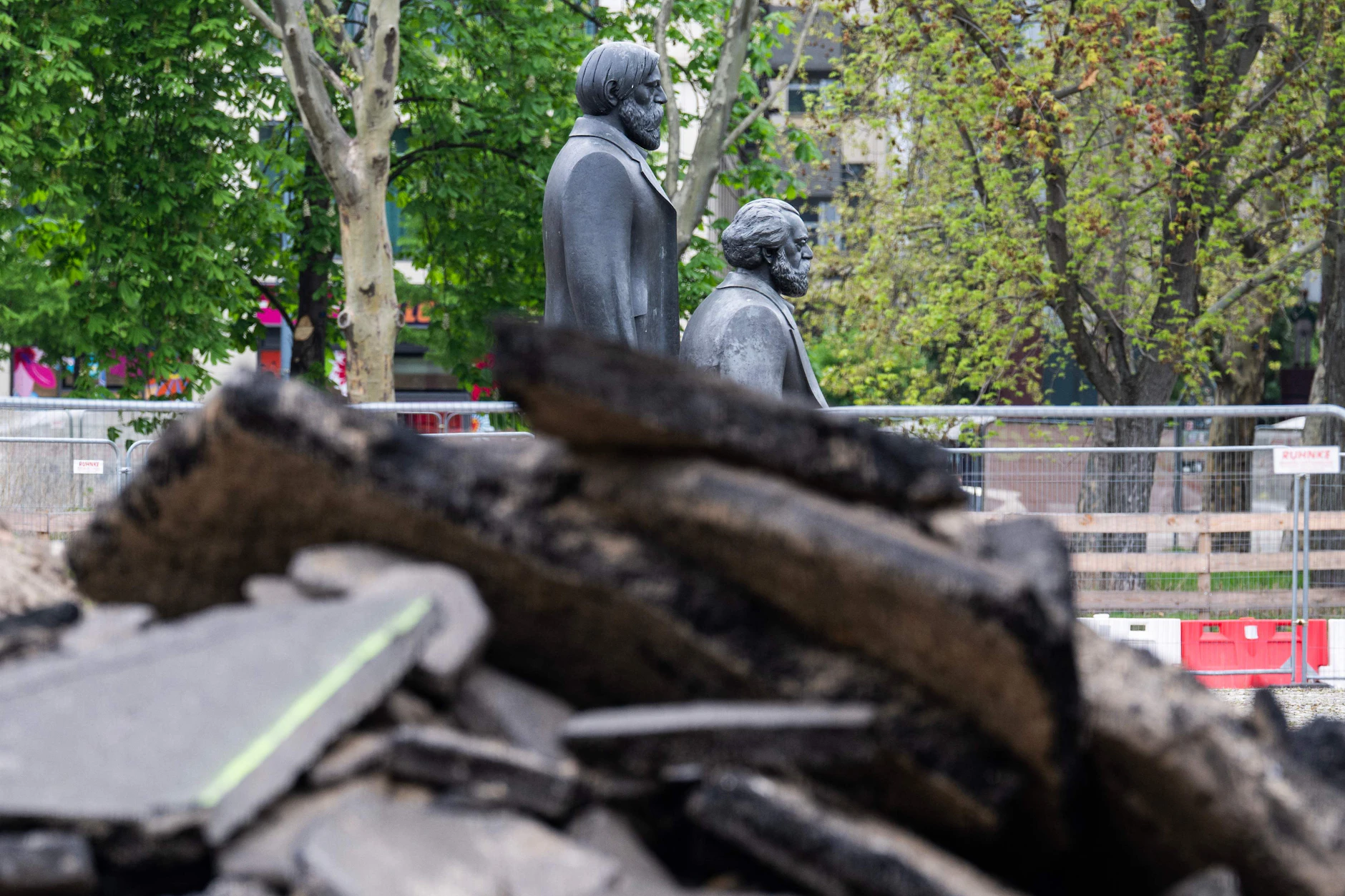 Marx und Engels blicken neben Schutt weiter auf den Fernsehturm.