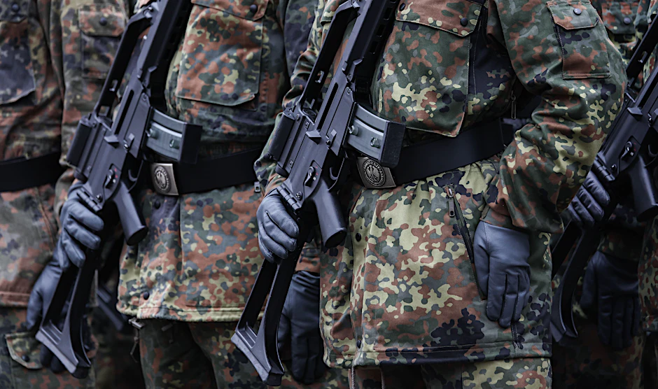Soldaten tragen Sturmgewehre während einer Veranstaltung.