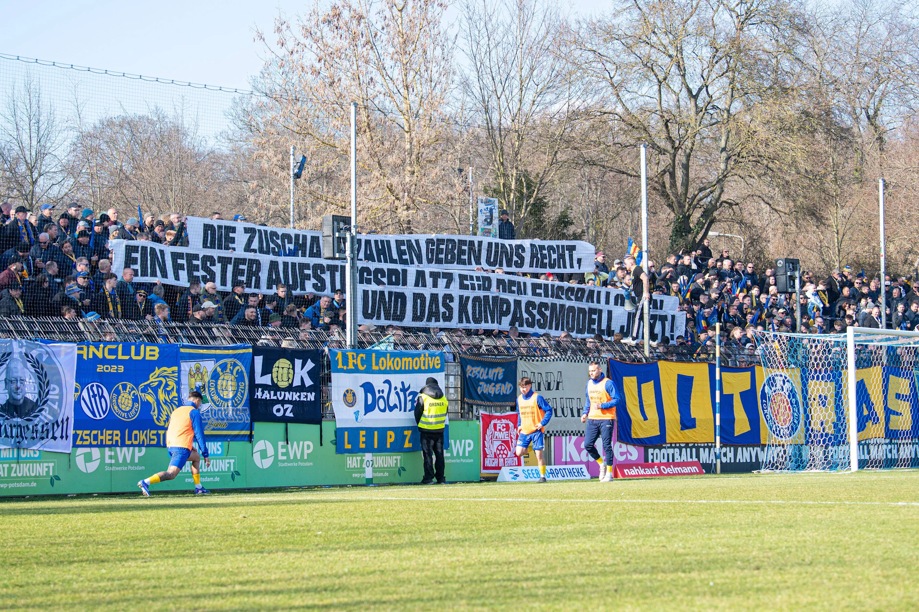 Fans von Lok Leipzig positionieren sich im März 2026 mit Transparenten zur Aufstiegsreform: „Die Zuschauerzahlen geben uns recht, ein fester Aufstiegsplatz für den Fußballosten und das Kompassmodell jetzt.“