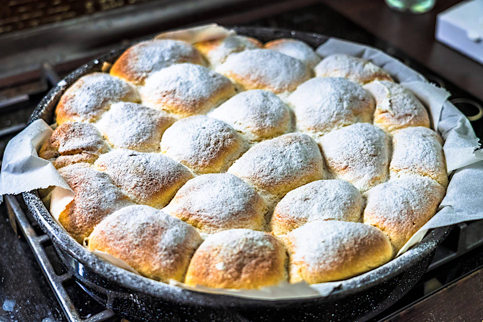 Einback erinnert an Milchbrötchen. Sie können diese auf einem Backblech oder in einer Springform zubereiten. Hier wurde das Gebäck mit Puderzucker bestäubt.