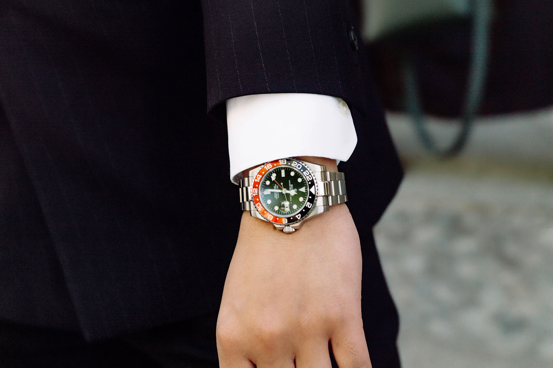 Seine klassische Herrengarderobe ergänzt er durch silberfarbene Akzente: Zur Rolex gesellen sich der „Juste un Clou“-Armreif von Cartier aus Weißgold und eine klassische Krawattennadel.