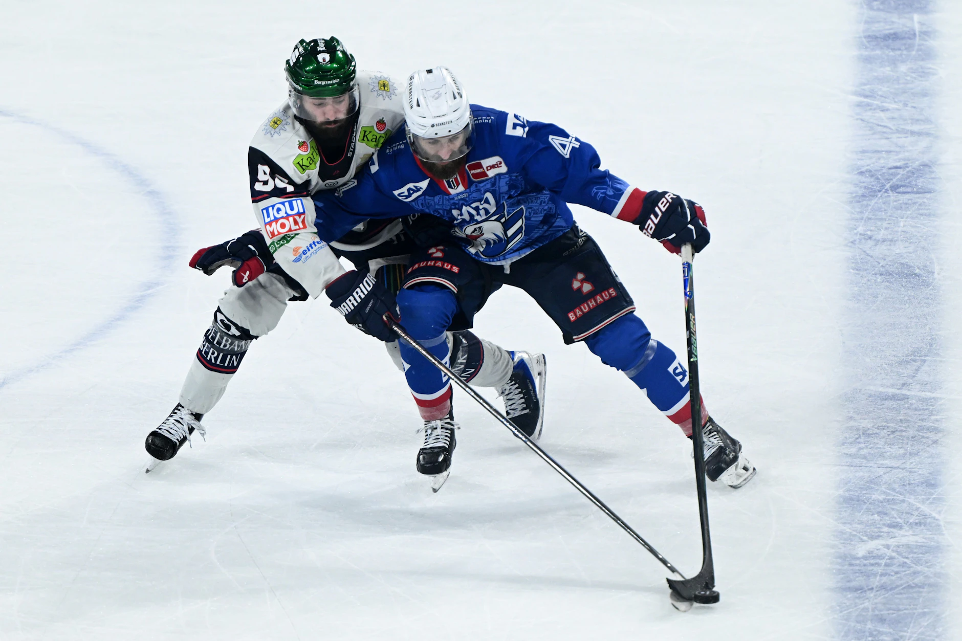 Liam Kirk (l., Eisbären Berlin) und Anthony Greco (Adler Mannheim) kämpfen um den Puck.