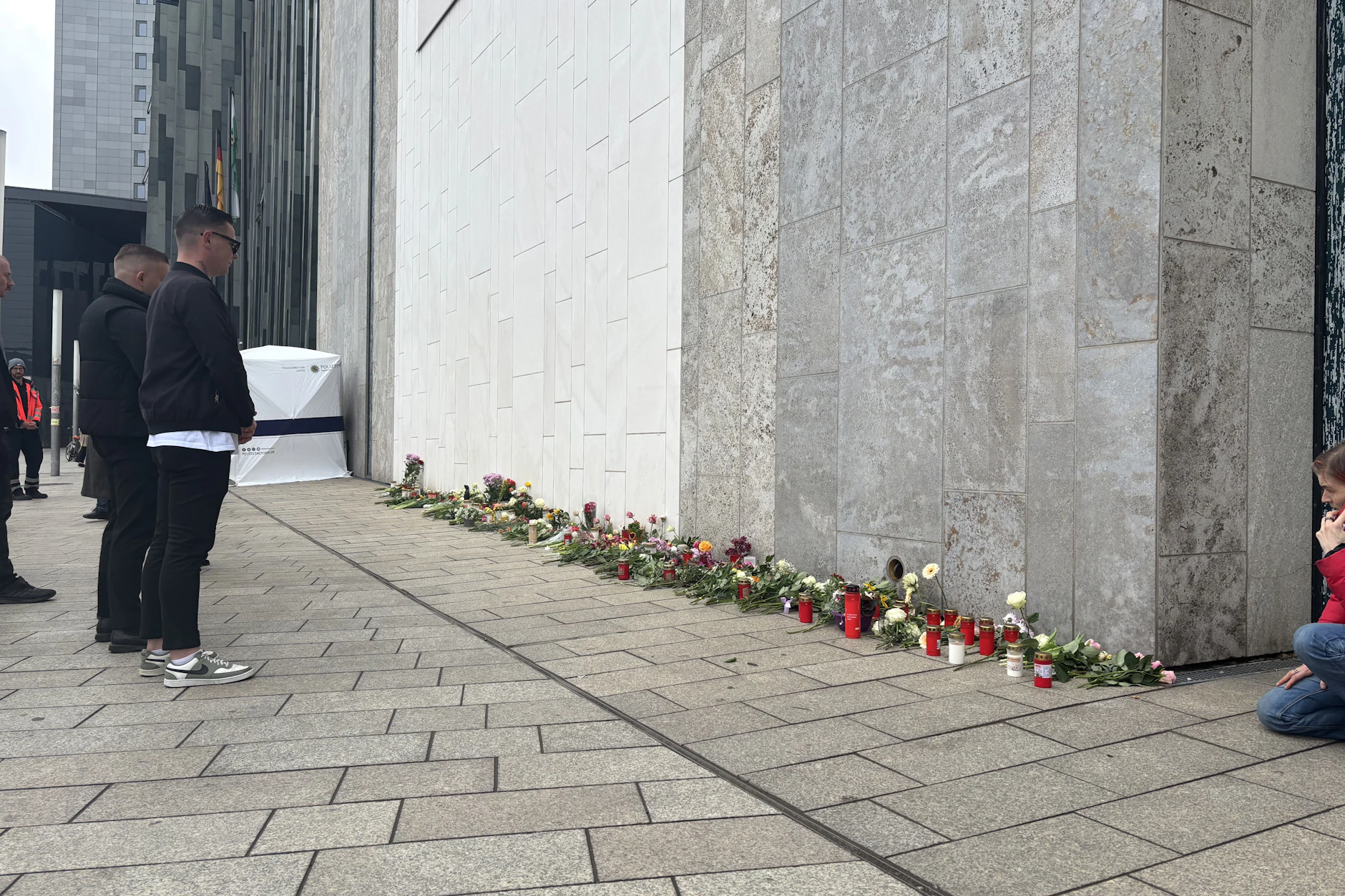 In der Leipziger Innenstadt legen Menschen Blumen und Kerzen nieder.