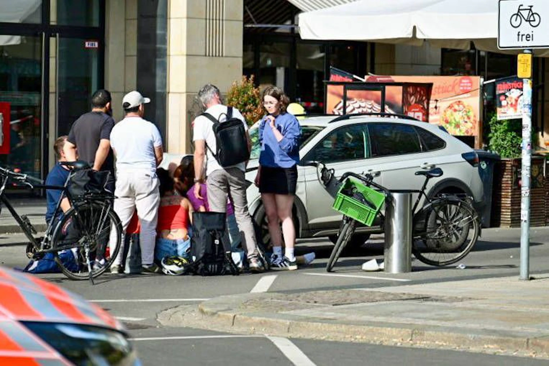 Passanten kümmern sich nach der Amokfahrt in Leipzig um Verletzte auf der Straße – zwei Menschen überlebten die Tat nicht.