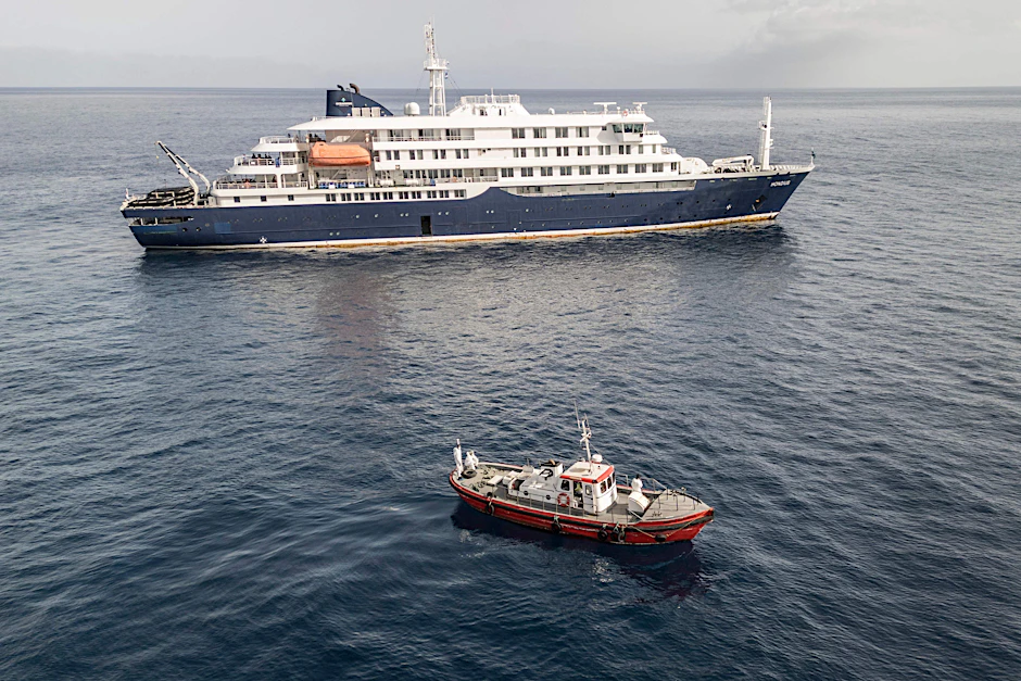 Ein Ambulanzboot mit Einsatzkräften in Schutzanzügen nähert sich vor Kap Verde dem Kreuzfahrtschiff „Hondius“.