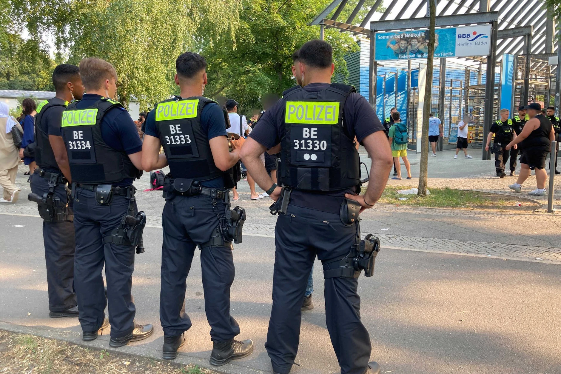 Polizisten stehen vor dem Eingang des Sommerbads in Neukölln. Das Bad musste wegen Rangeleien und renitenter Besucher öfter frühzeitig geschlossen und geräumt worden. 