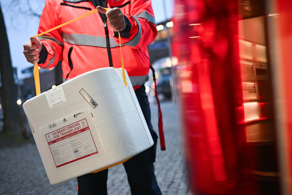 Ein Mitarbeiter der Malteser stellt eine Kühlbox für eine Organspende in einen Transporter.