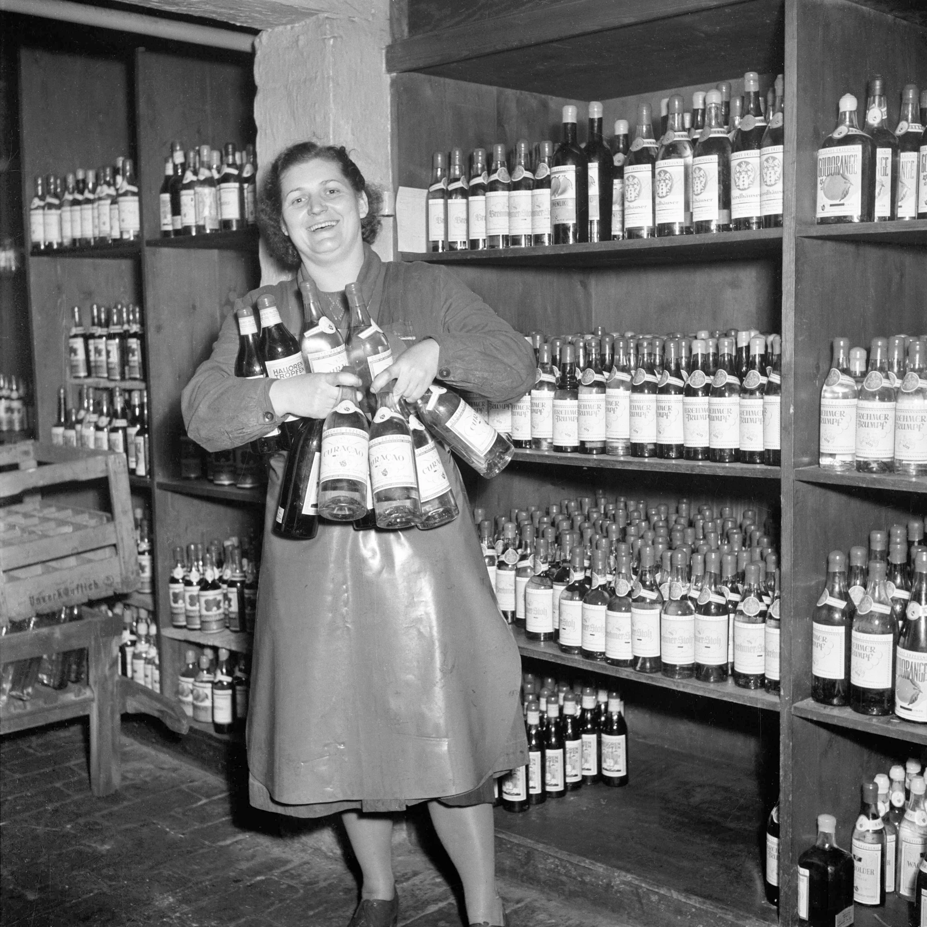 Eine Mitarbeiterin eines Spirituosenlagers in Sangerhausen mit Likörflaschen. In der DDR wurde bei Feierlichkeiten gern mal geschnäpselt.