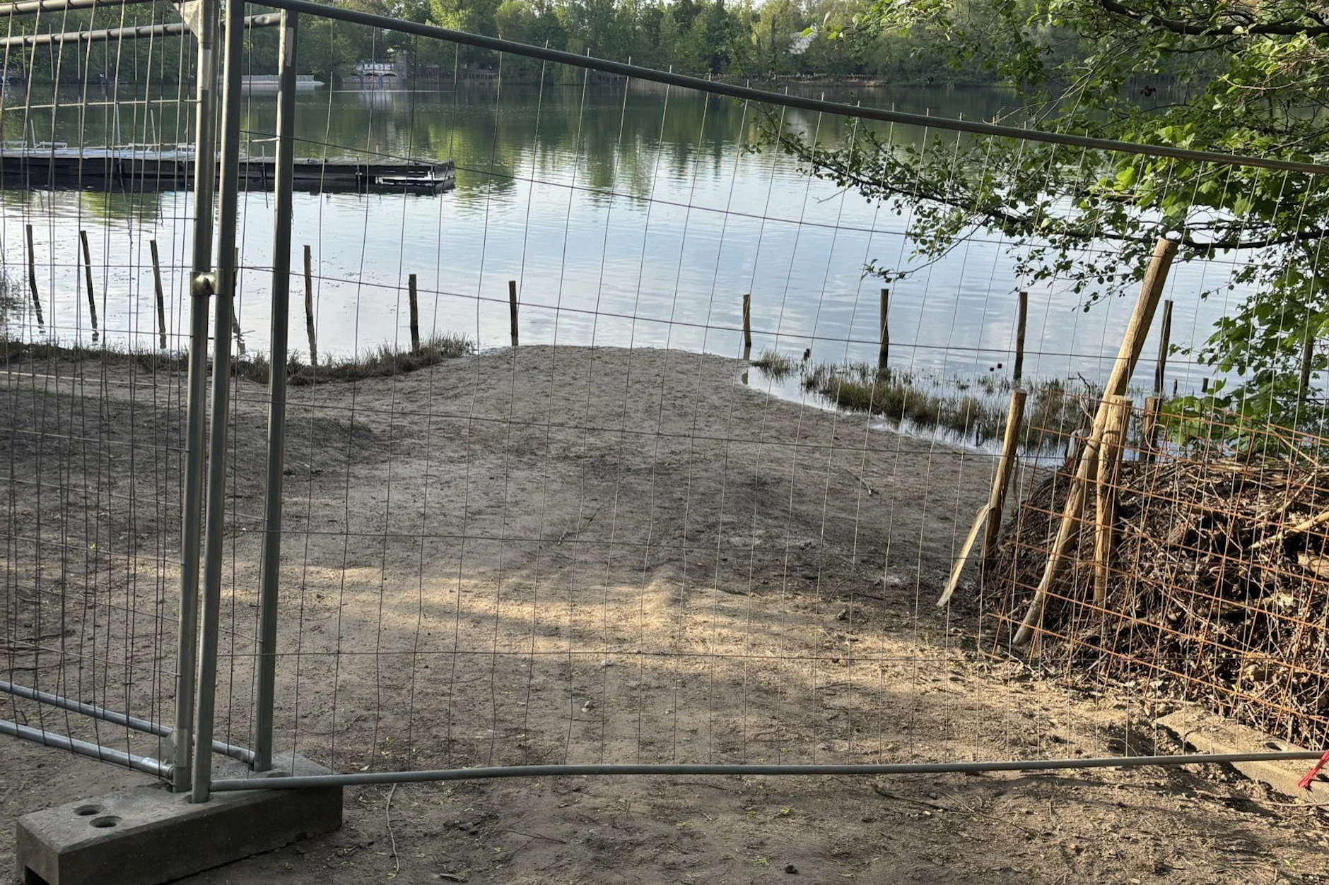 Bauzaun am Ufer des Weißen Sees. Da, wo die Hecke endet, muss noch ein Tor eingebaut werden.