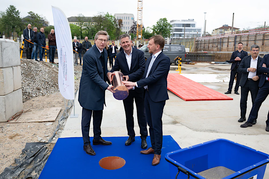  Oliver Wehner, Geschäftsführer des Herzzentrums Dresden, Thomas Lemke, Vorsitzender des Vorstandes, Sana Kliniken AG, und Michael Kretschmer (CDU), Ministerpräsident von Sachsen, halten auf der Baustelle des künftigen Herzzentrum Dresden zur Grundsteinlegung die Zeitkapsel. 