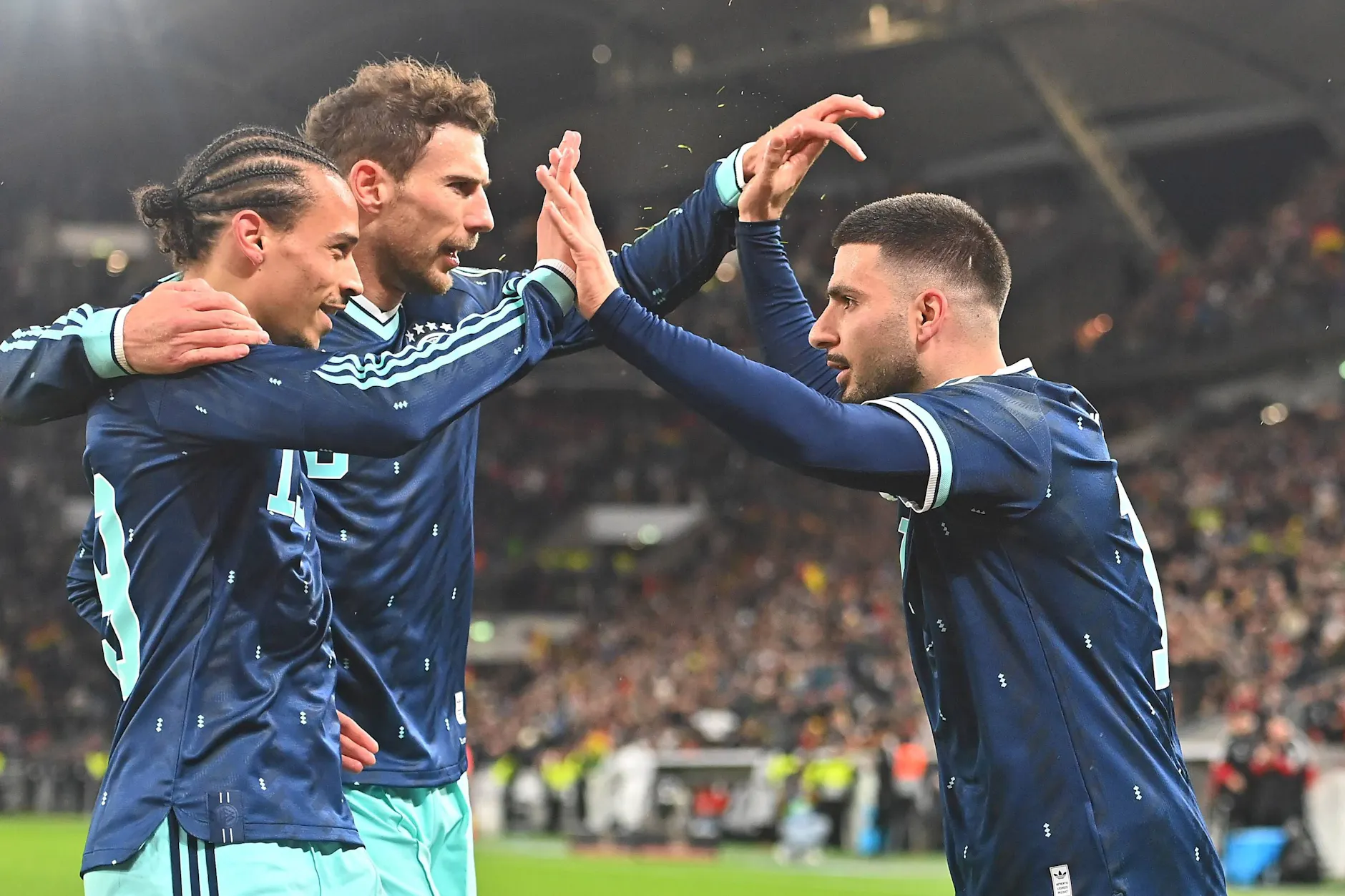 Deniz Undav, Leon Goretzka und Leroy Sane jubeln im März über das 2:1 gegen Ghana. Die WM-Vorrundenspiele der DFB-Elf finden in Houston (14. Juni, Curacao), Toronto (20. Juni, Elfenbeinküste) und East Rutherford (25. Juni, Ecuador) statt.