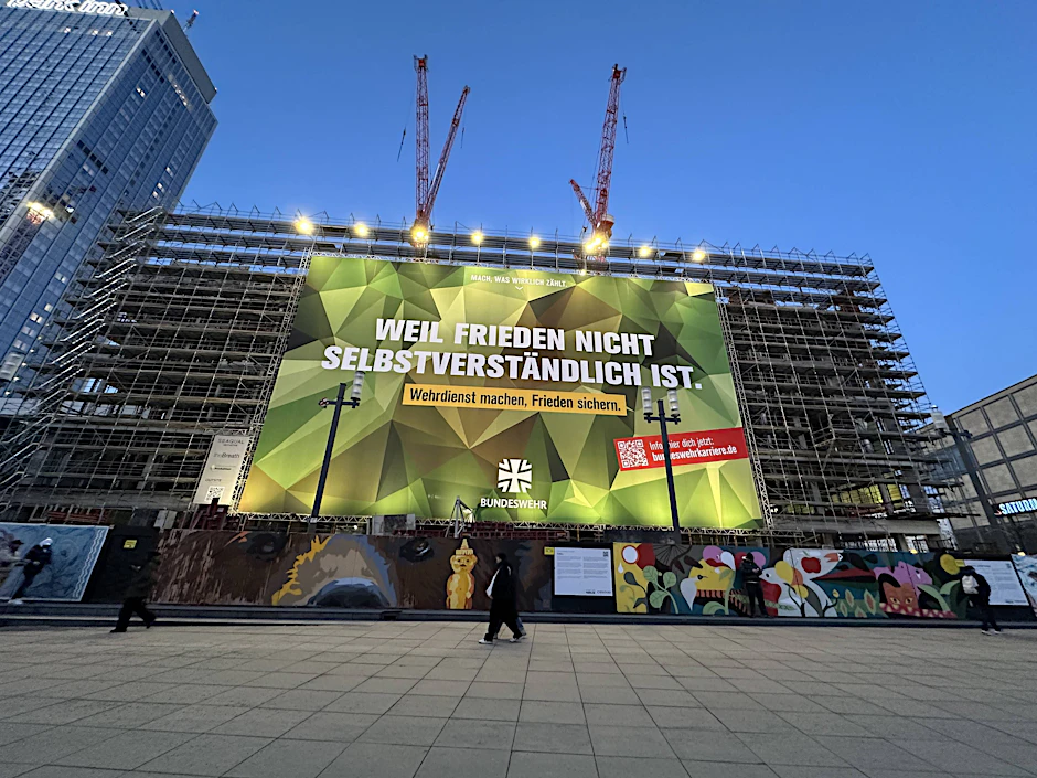 Werbeplakat der Bundeswehr an einer Baustelle am Alexanderplatz.