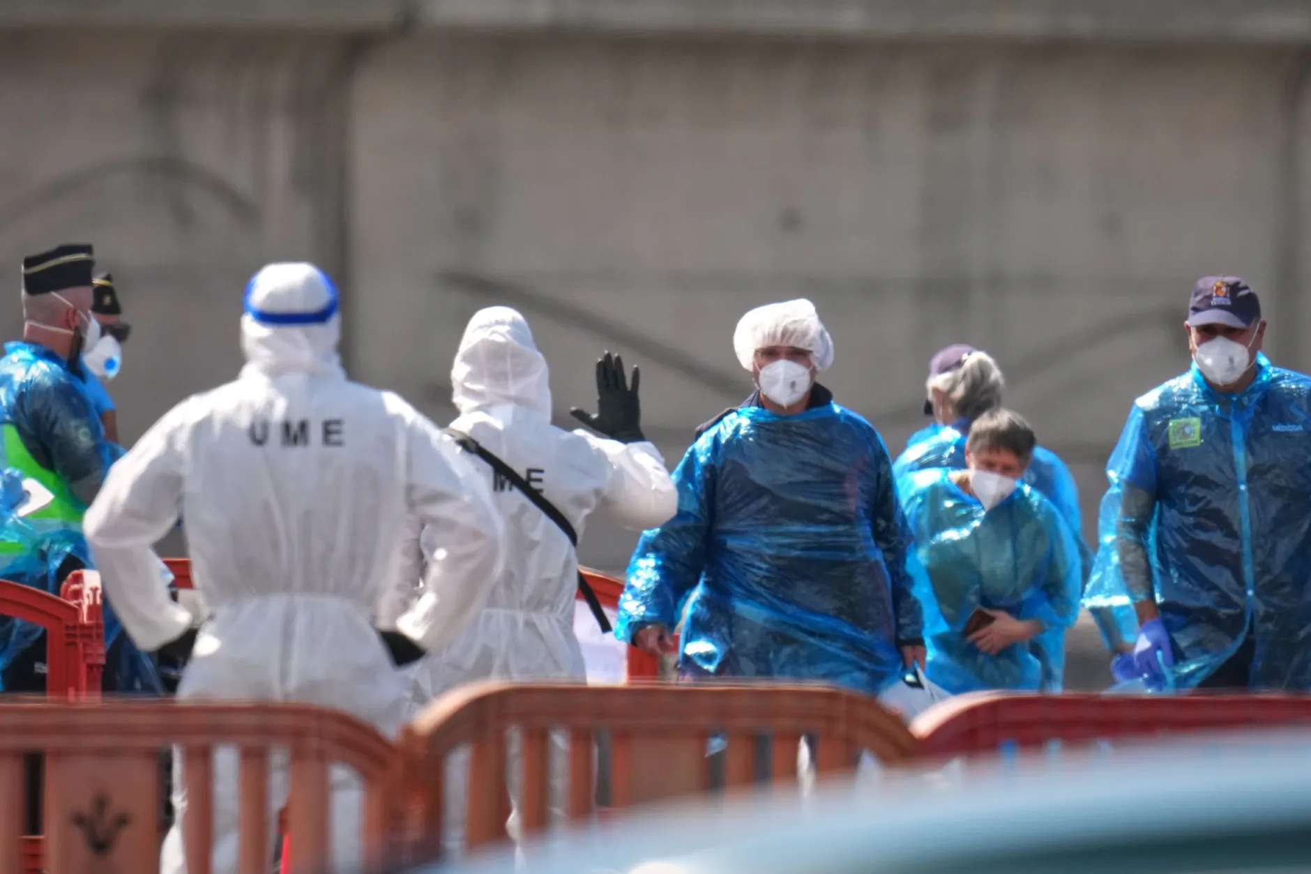 Unter strengsten Sicherheitsvorkehrungen verlassen die Passagiere der „Hondius" das Schiff – in blauen Schutzanzügen, begleitet von Einsatzkräften der spanischen Militärnotfalleinheit UME.