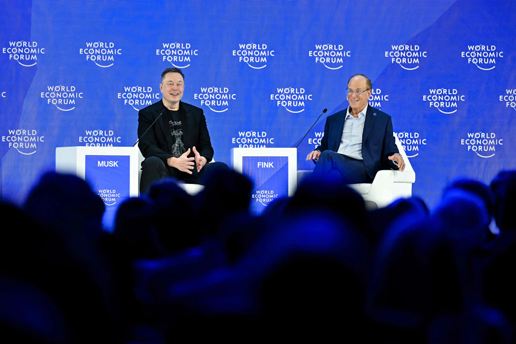 Elon Musk und BlackRock-Chef Larry Fink beim Weltwirtschaftsforum in Davos im Januar 2026. Beide gehören zur Wirtschaftsdelegation, die Donald Trump nach China begleitet.
