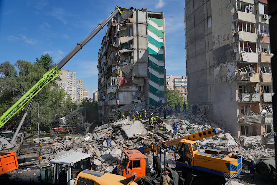 Rettungskräfte räumen die Trümmer, nachdem eine russische Rakete während eines massiven Luftangriffs in ein Wohnhaus in Kiew eingeschlagen ist.