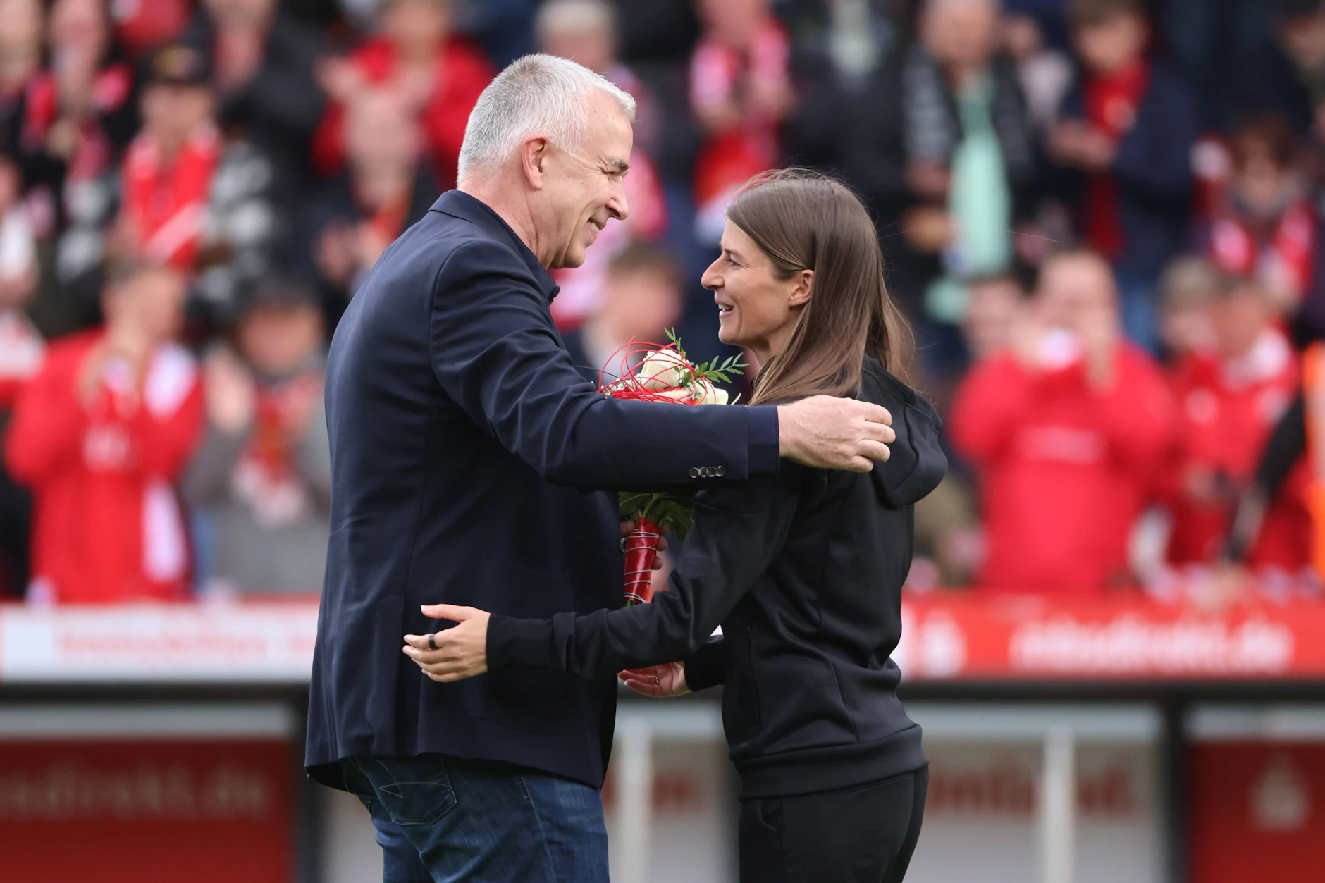 Dirk Zingler (l.) herzt Marie-Louise Eta vor dem letzten Saisonspiel.