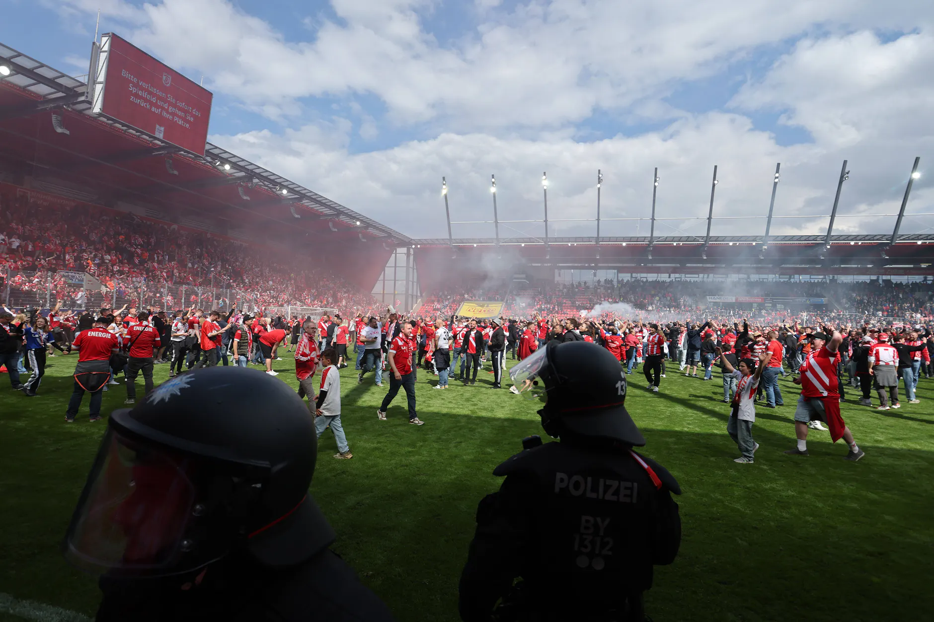 Cottbus steigt in die 2. Bundesliga auf. Die Energie-Fans stürmten nach dem 1:0-Auswärtssieg bei Jahn Regensburg den Rasen.