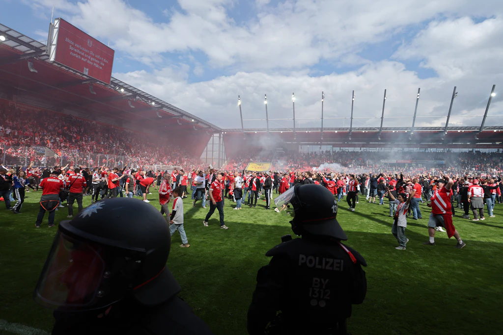 Cottbus steigt in die 2. Bundesliga auf. Die Energie-Fans stürmten nach dem 1:0-Auswärtssieg bei Jahn Regensburg den Rasen.