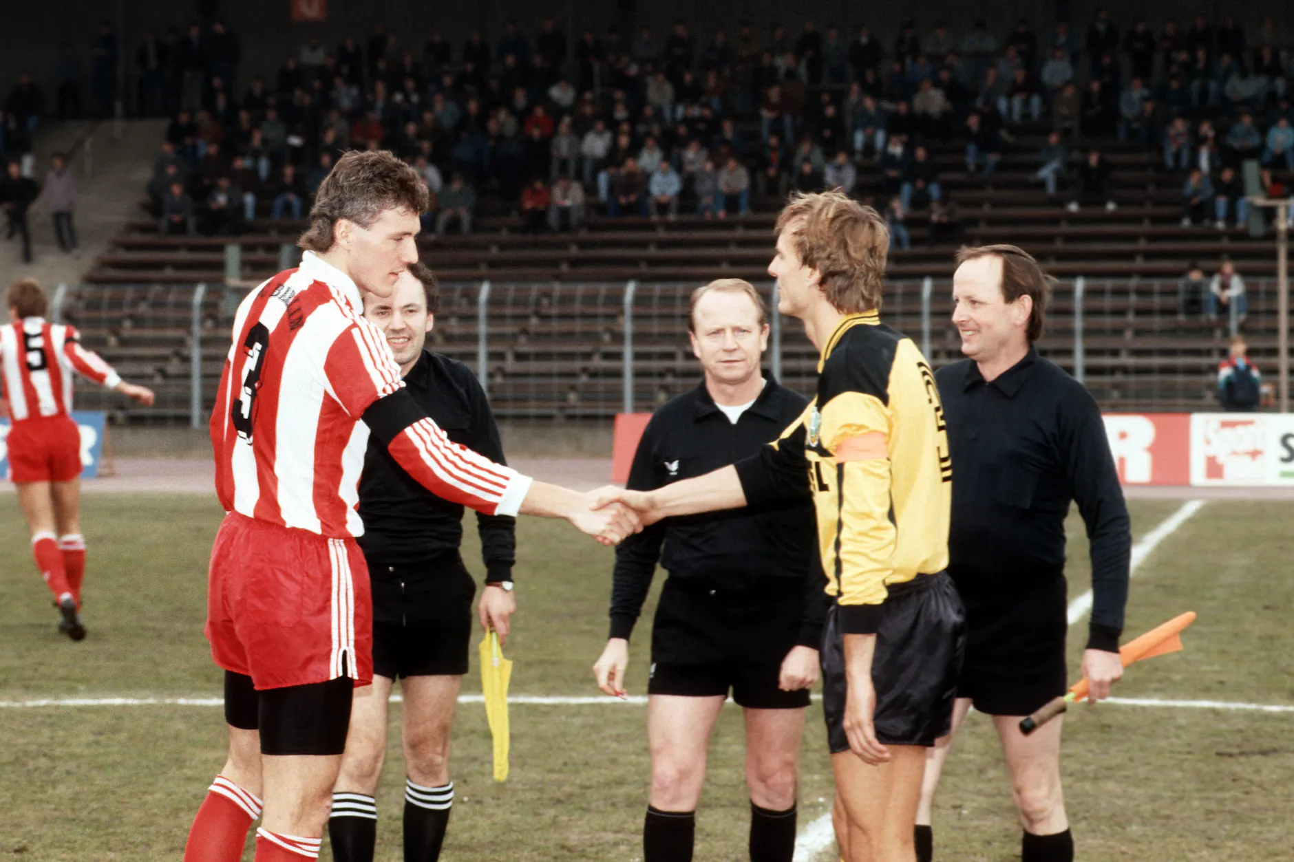 Die Kapitäne Burkhard Reich (FC Berlin/l.) und Frank Lieberam (Dresden/r.) bei der Platzwahl im März 1991.