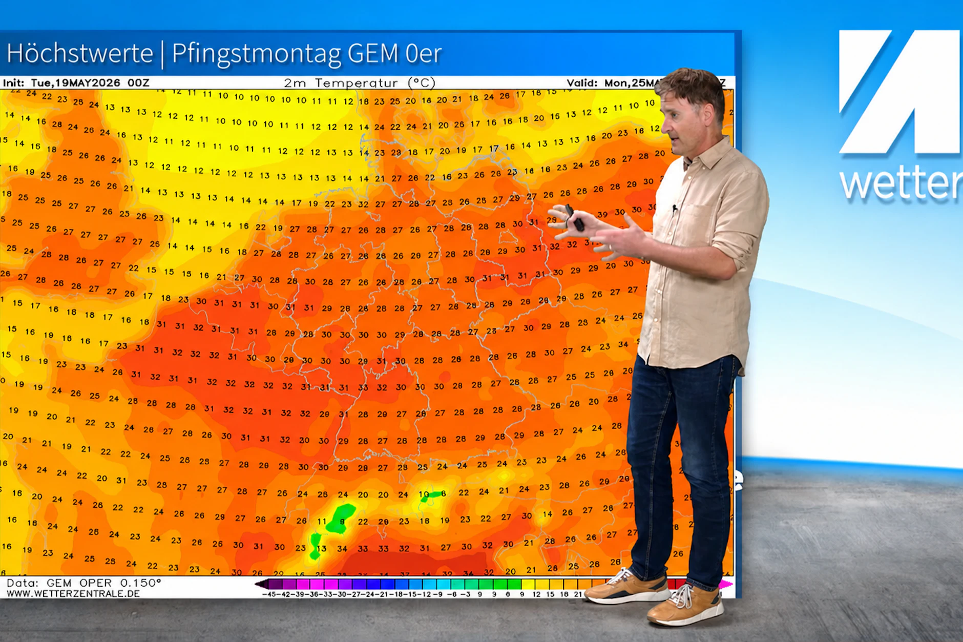 Dominik Jung von wetter.net steht vor einer Wetterkarte des kanadischen Wettermodells für Pfingstmontag. Mit Temperaturen von bis 33 Grad in Rheinland‑Pfalz und Baden‑Württemberg. 