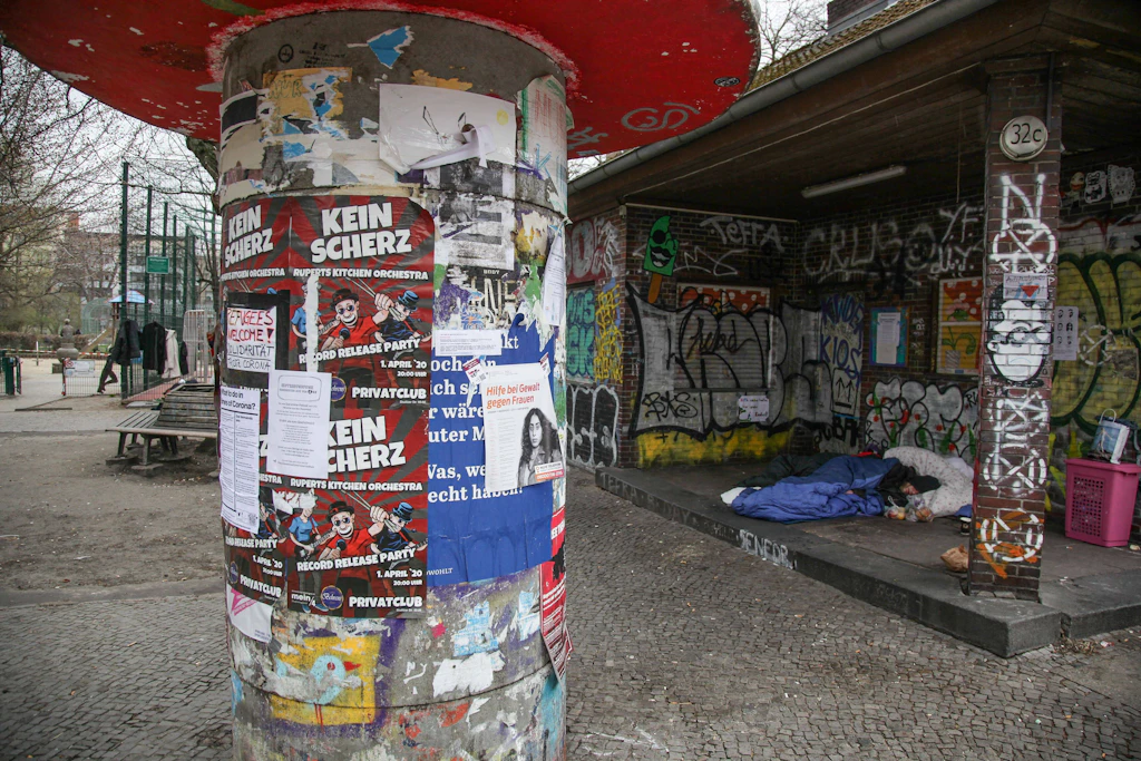 Ein Obdachloser schläft auf der Erde am Reuterplatz in Neukölln.