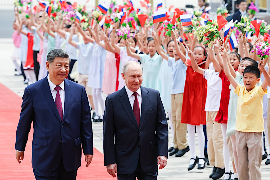 Wie bei Donald Trumps Besuch begrüßen wieder Kinder Chinas Präsident Xi Jinping und seinen russischen Amtskollegen Wladimir Putin in Peking.