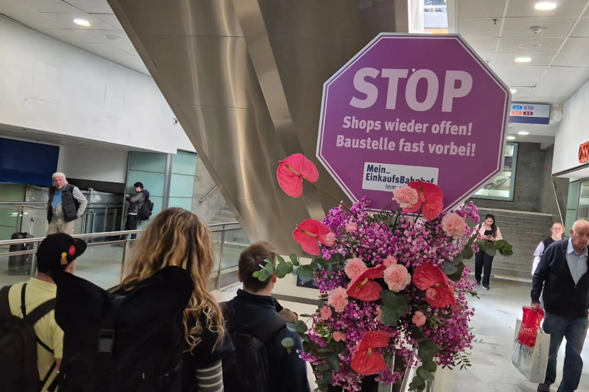 Im Bahnhof Friedrichstraße sind lauter Blumensträuße und Stoppschilder aufgetaucht. Beim genauen Hinsehen klärt sich auf, was dahintersteckt.