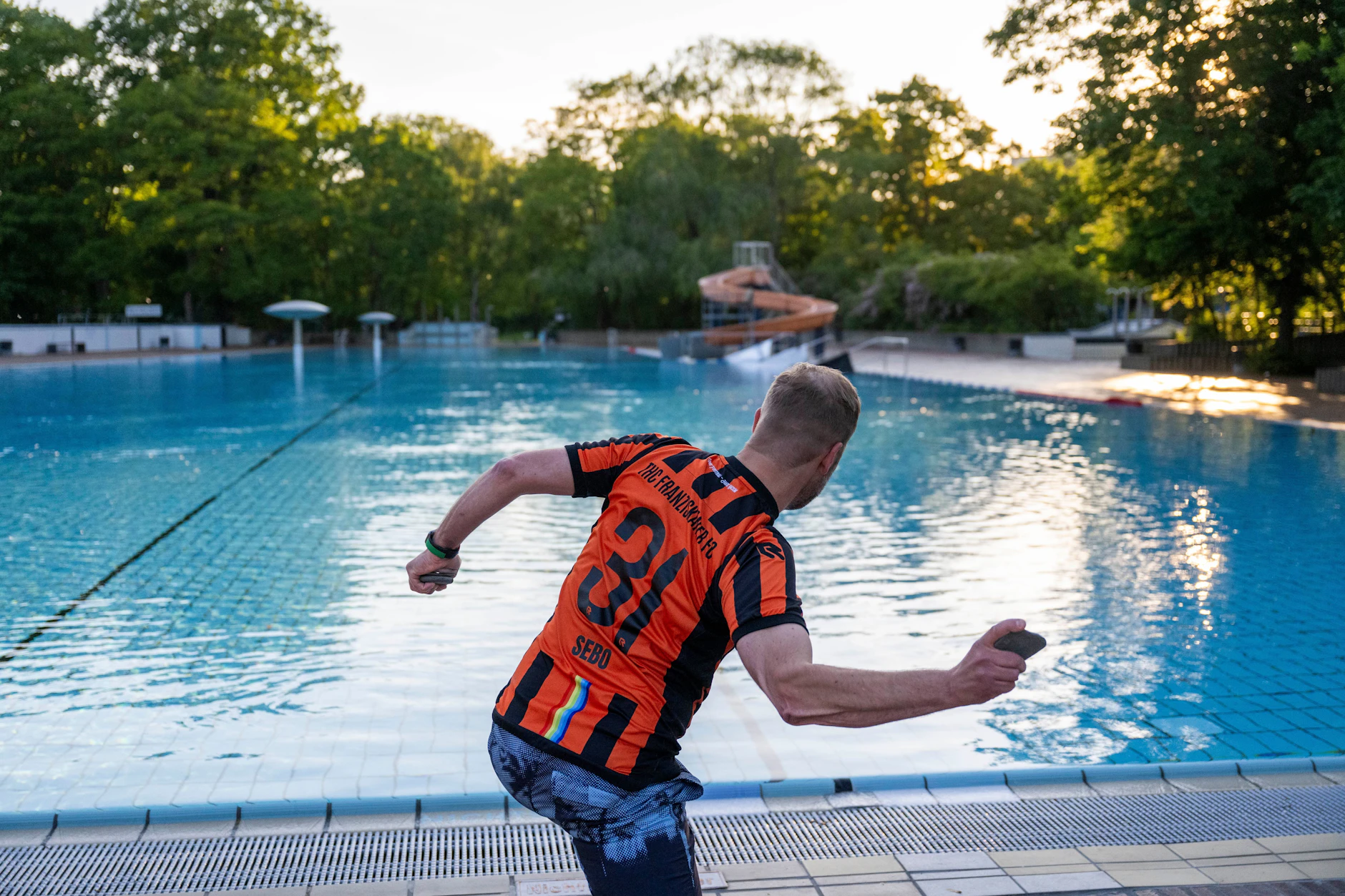 Sebastian Naumann, Abteilungsleiter Titschern beim THC Franziskaner FC, wirft an einem Trainingstag einen Stein in das 75 Meter lange Nichtschwimmerbecken im Sommerbad Kreuzberg.